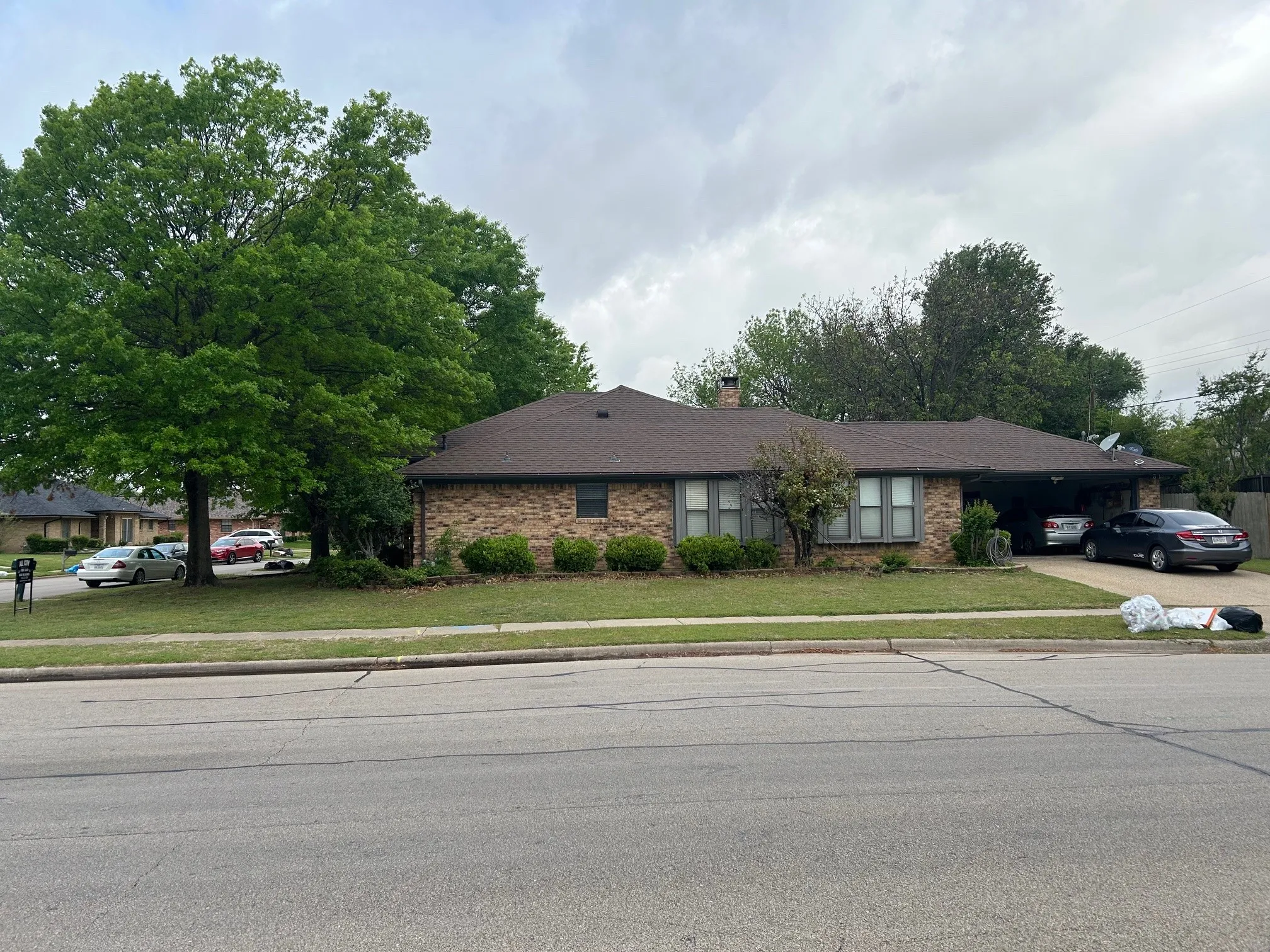 Single story home with a front lawn, driveway, a chimney, and brick siding