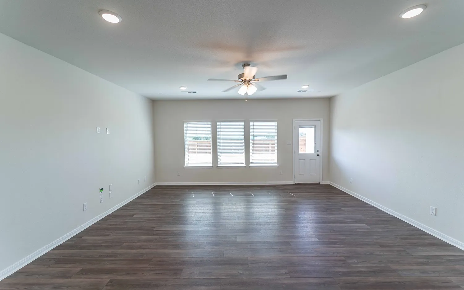 Spacious room featuring wood-finish flooring, recessed lighting, and a ceiling fan