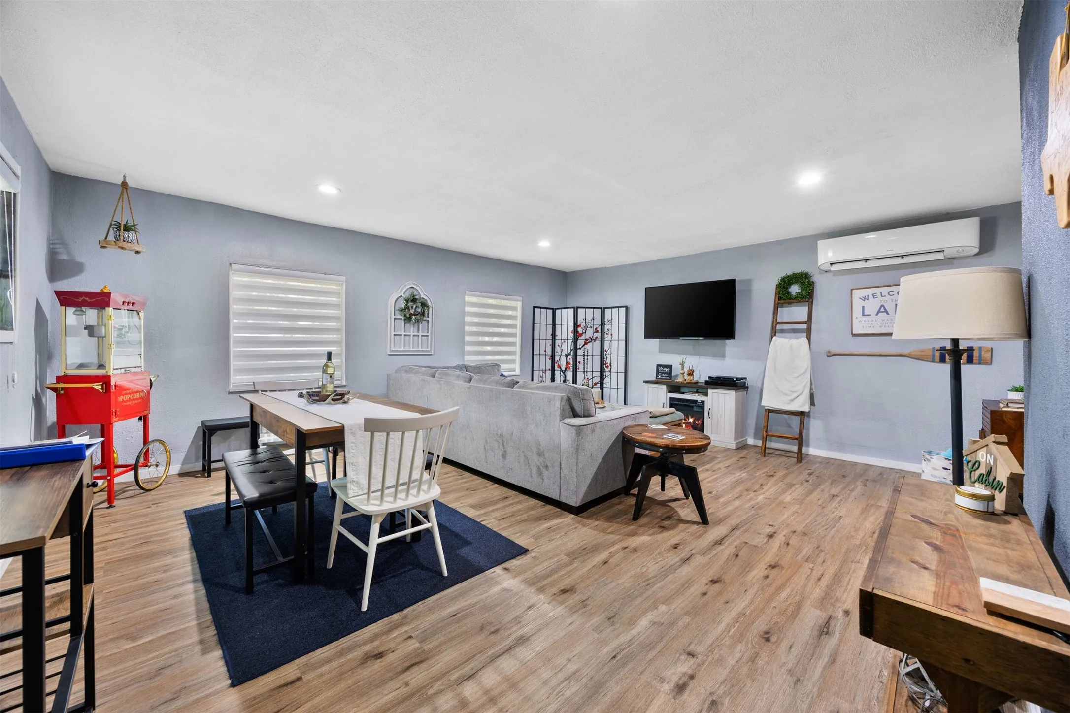 Open-concept living space featuring wood-finish flooring, recessed lighting, and light blue wall tones