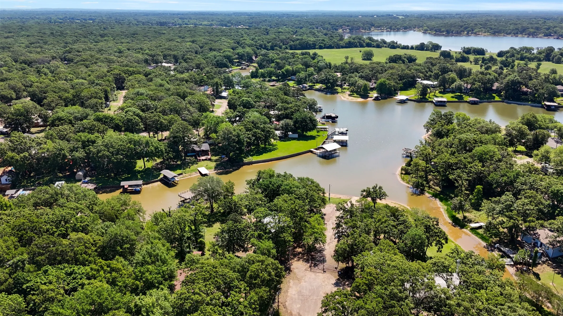 Expansive waterfront property featuring mature tree coverage and direct lake access