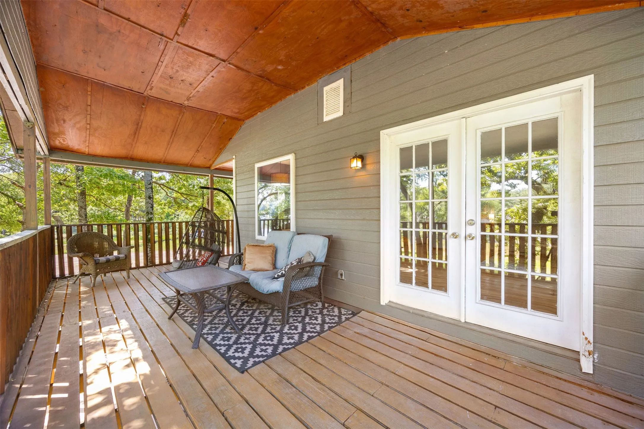 Expansive covered porch featuring wood flooring, wood-paneled walls, and a wood ceiling