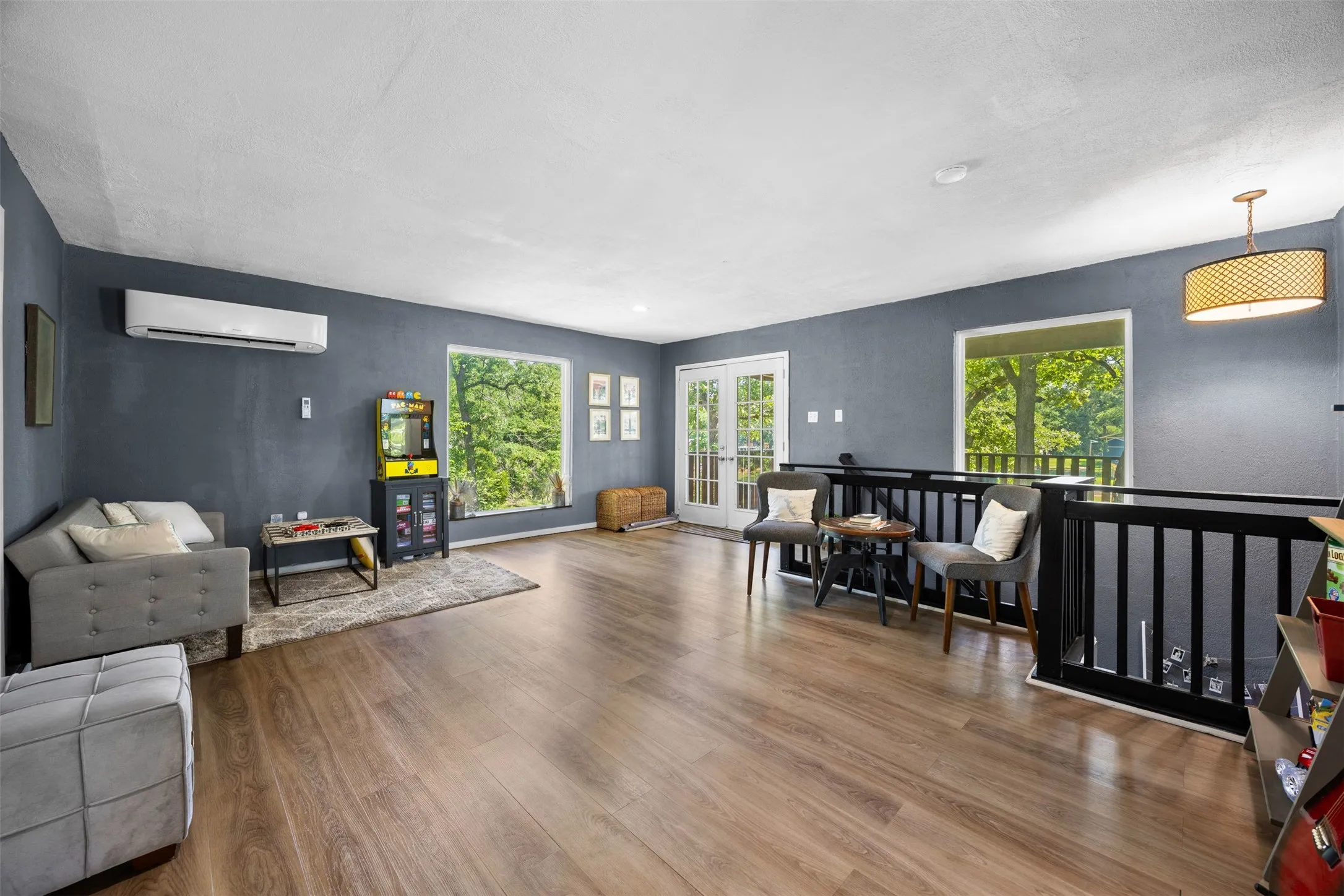 Spacious interior featuring wood-finish flooring, dark grey walls, and a white ceiling