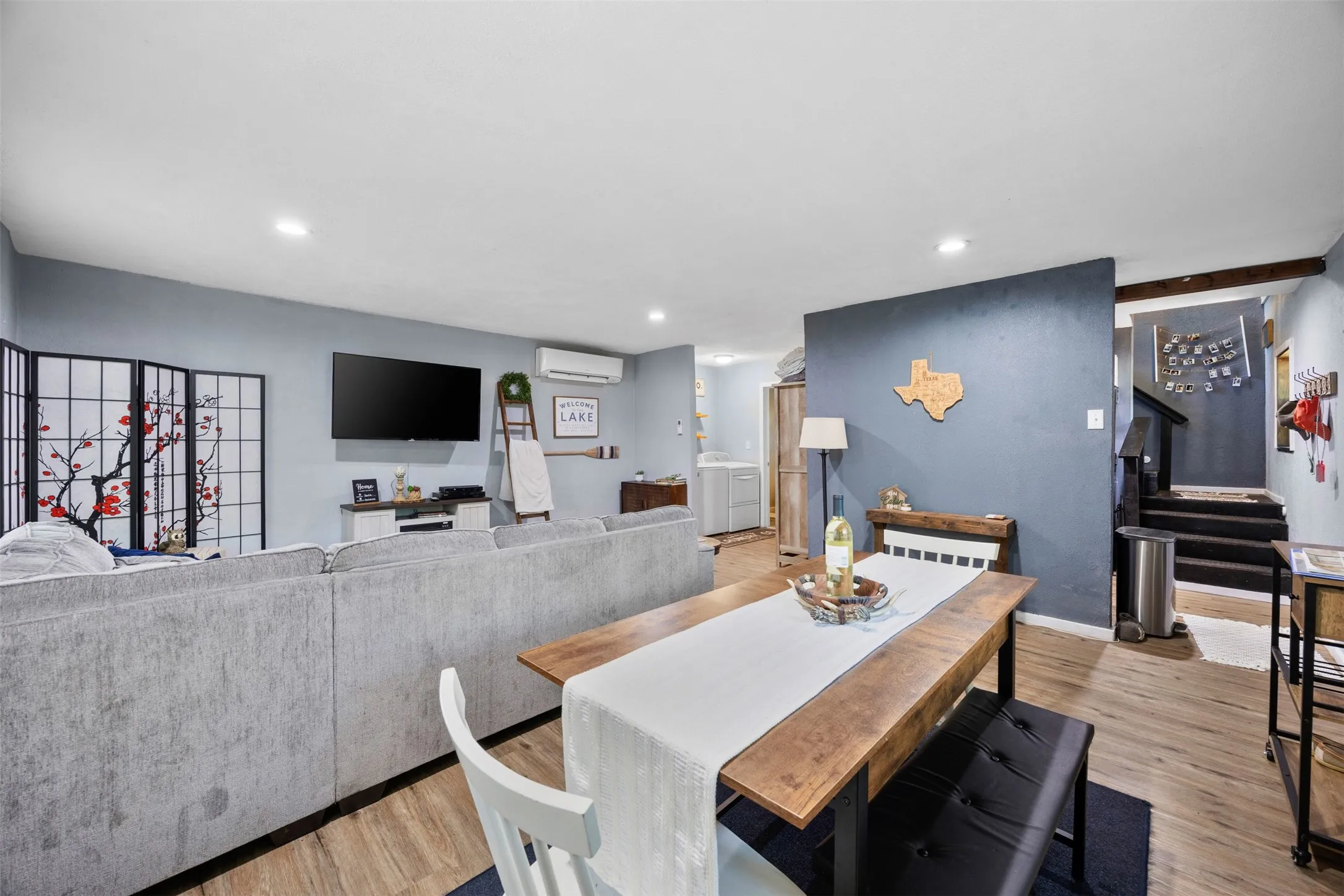 Open-concept living space featuring wood-finish flooring, recessed lighting, and a neutral color palette