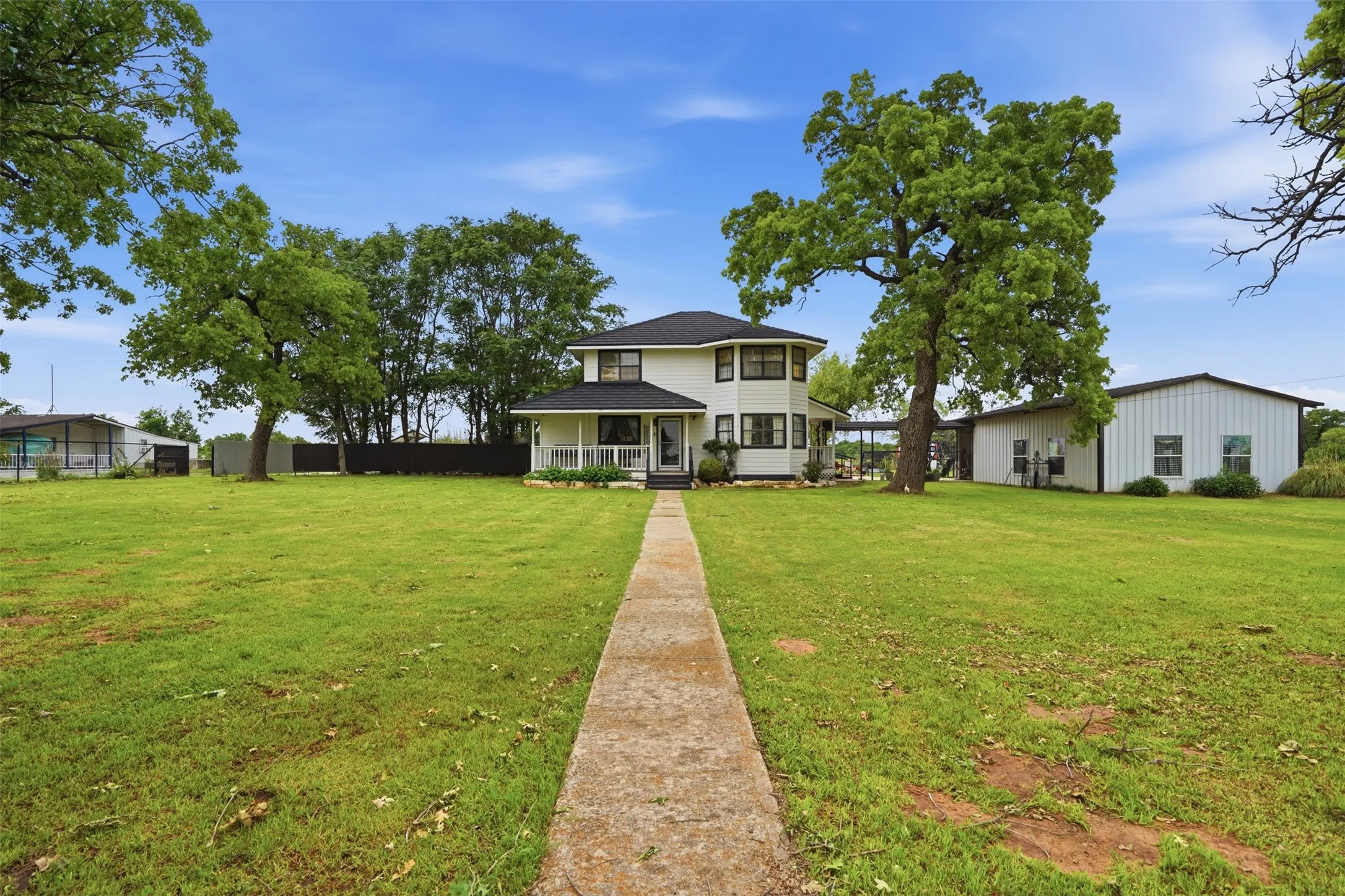 Two-story residential structure with a covered front porch and concrete walkway