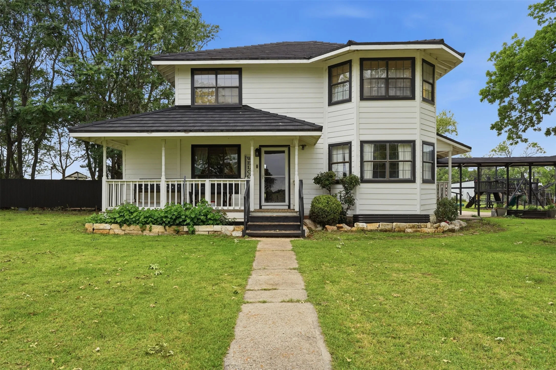 Two-story residence featuring white siding and black trim accents