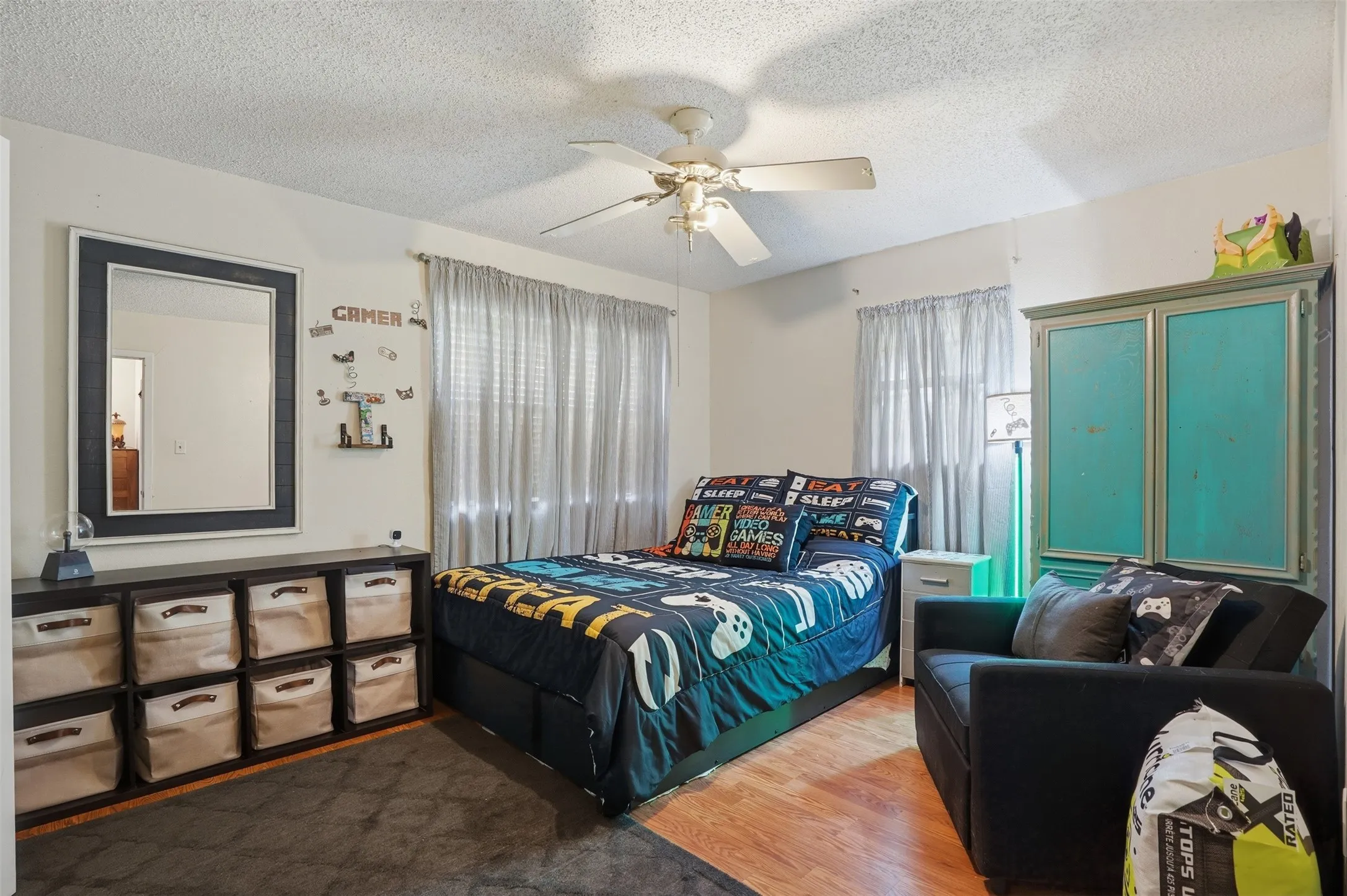 Hardwood-finish flooring complementing light-toned walls and a ceiling fan
