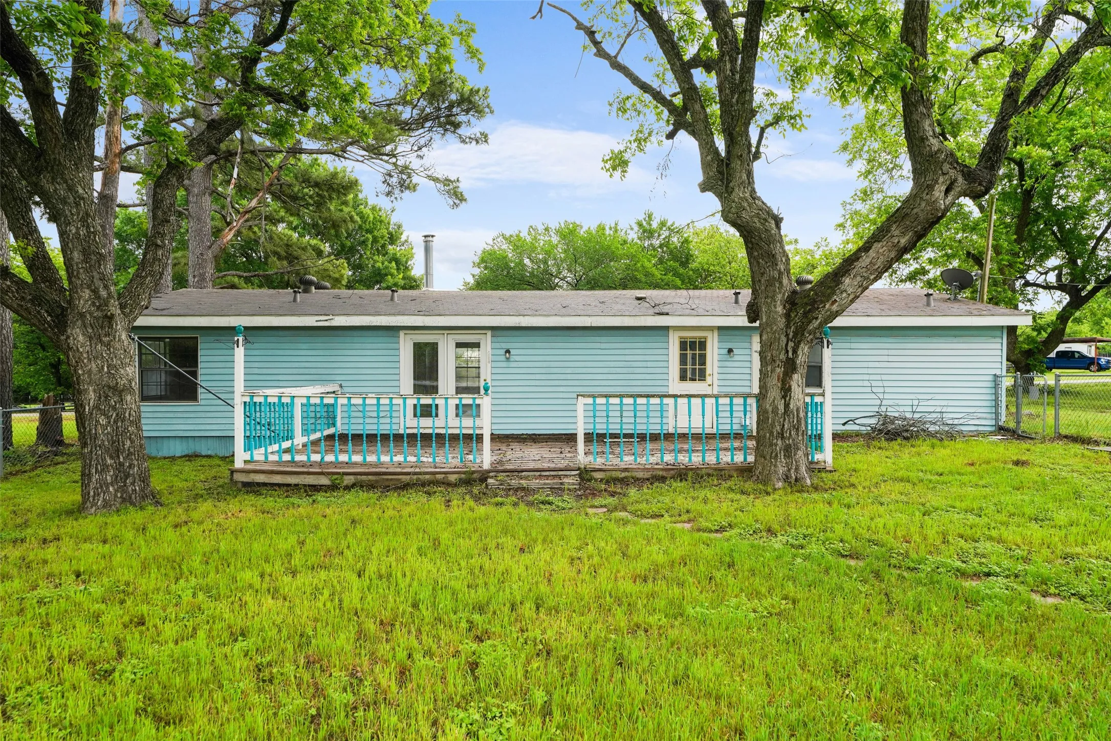 Rear exterior featuring blue siding and a wooden deck with blue and white railings