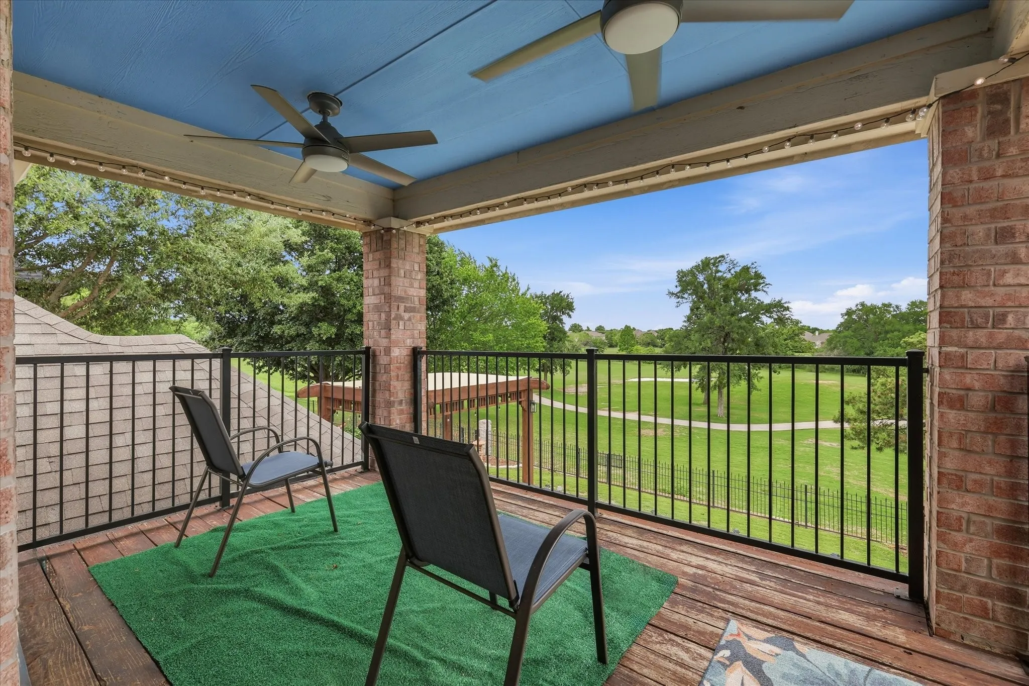 Covered balcony with a wood-finish floor and brick columns