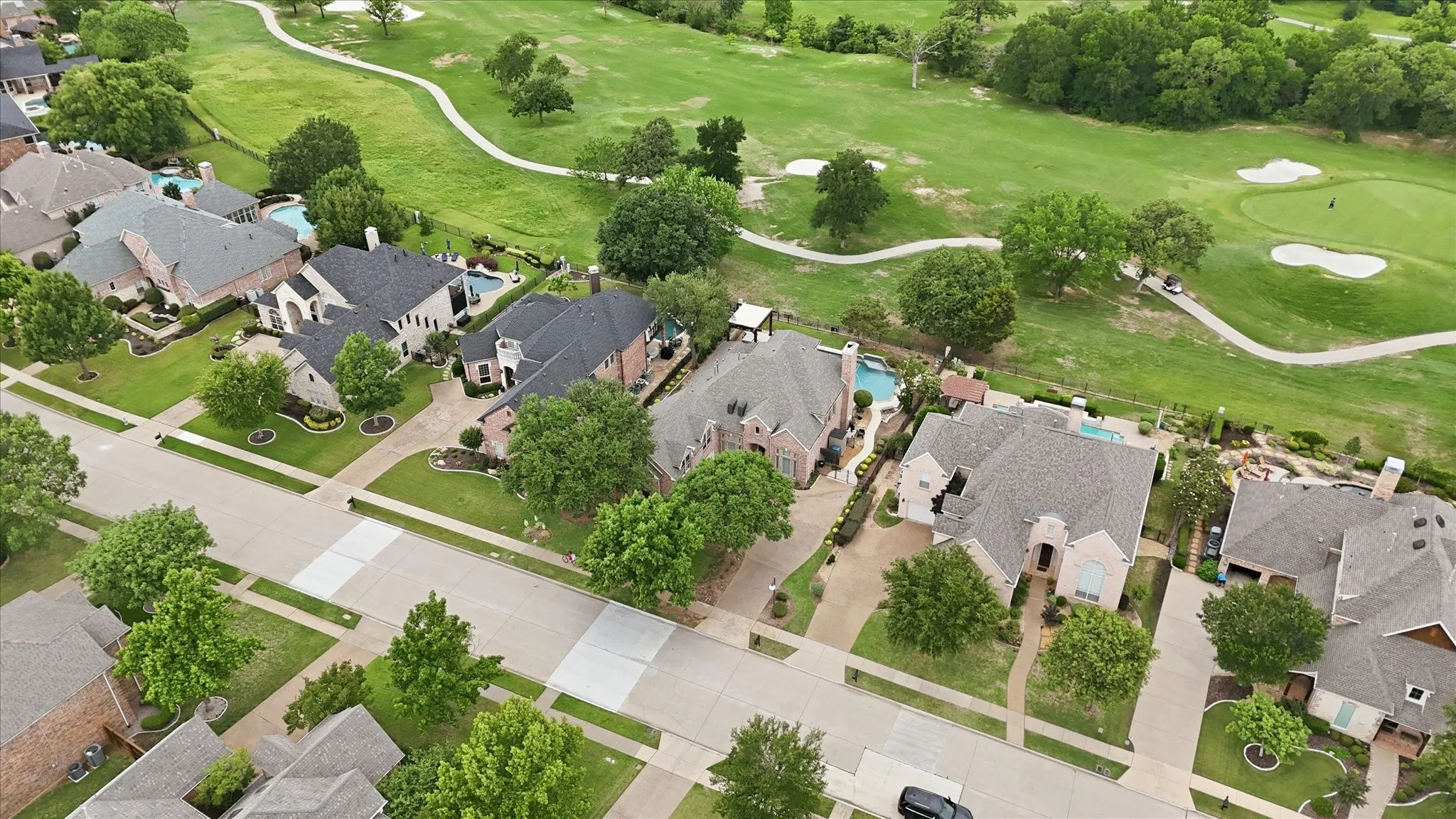 Aerial perspective featuring a residential street with properties backing onto a golf course