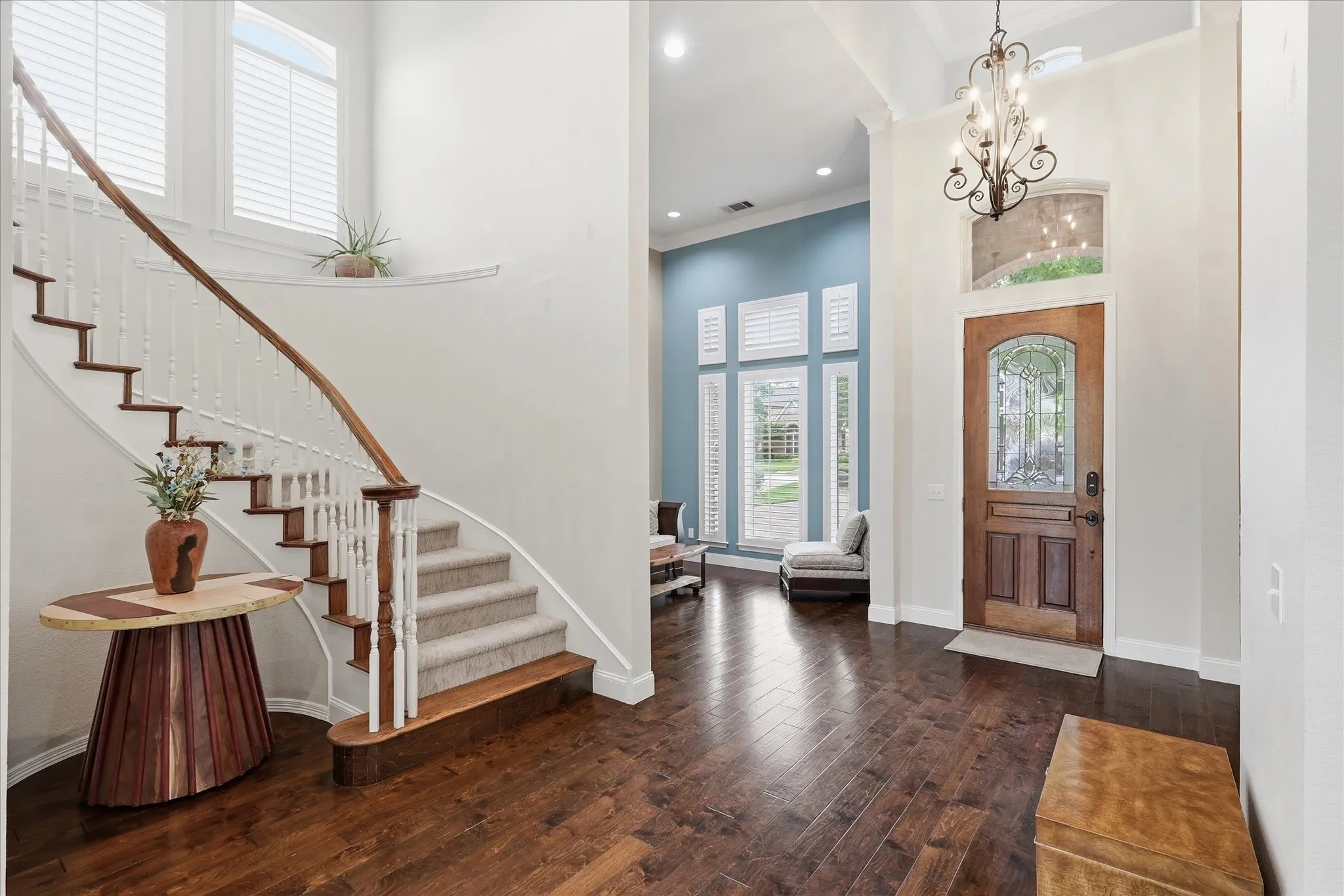 Grand entry featuring wood-finish flooring, and a curved staircase with white spindles and wood accents