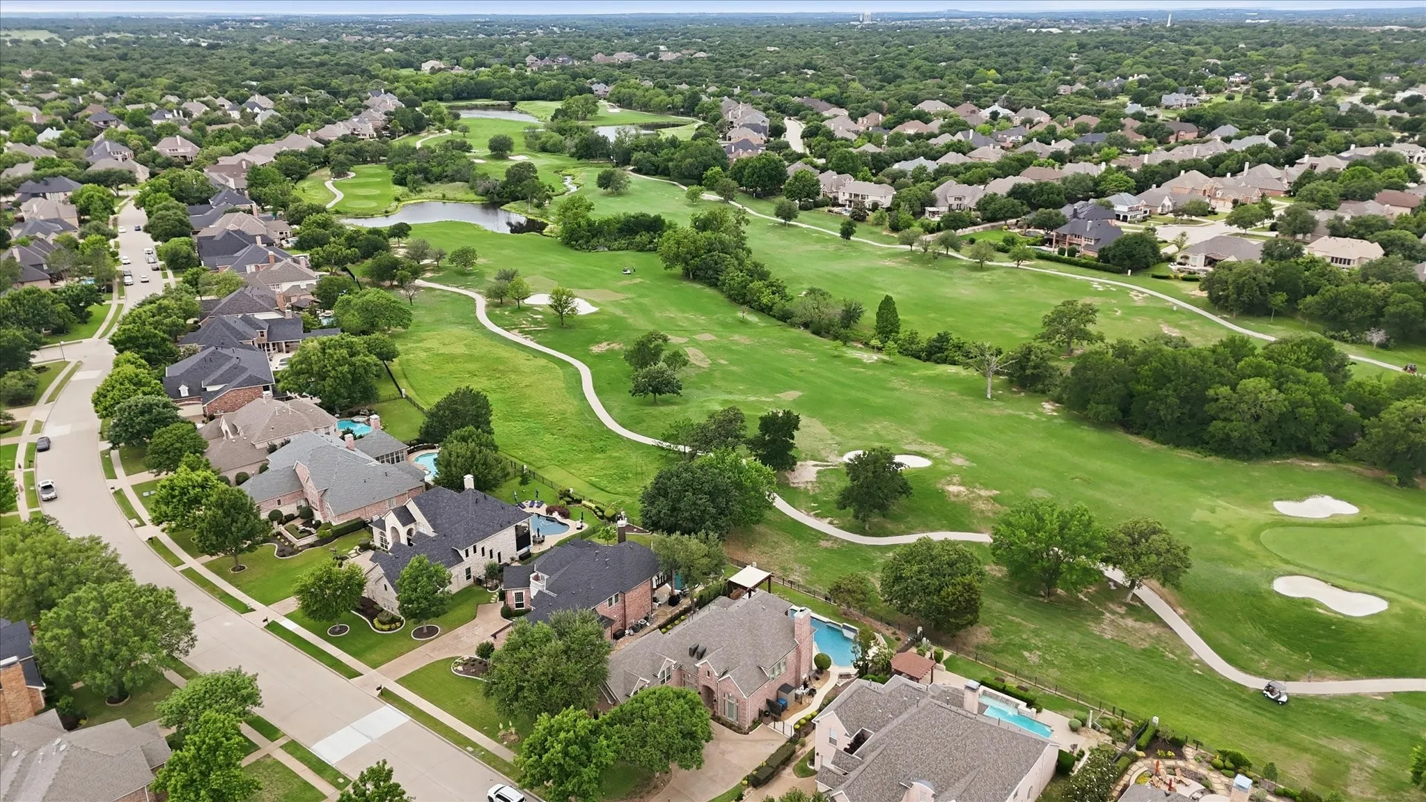 Aerial perspective showcasing a residential community bordering a golf course