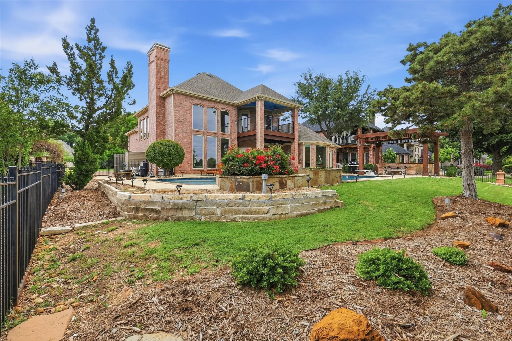 Brick exterior with tall windows, a prominent chimney, and a multi-level outdoor area