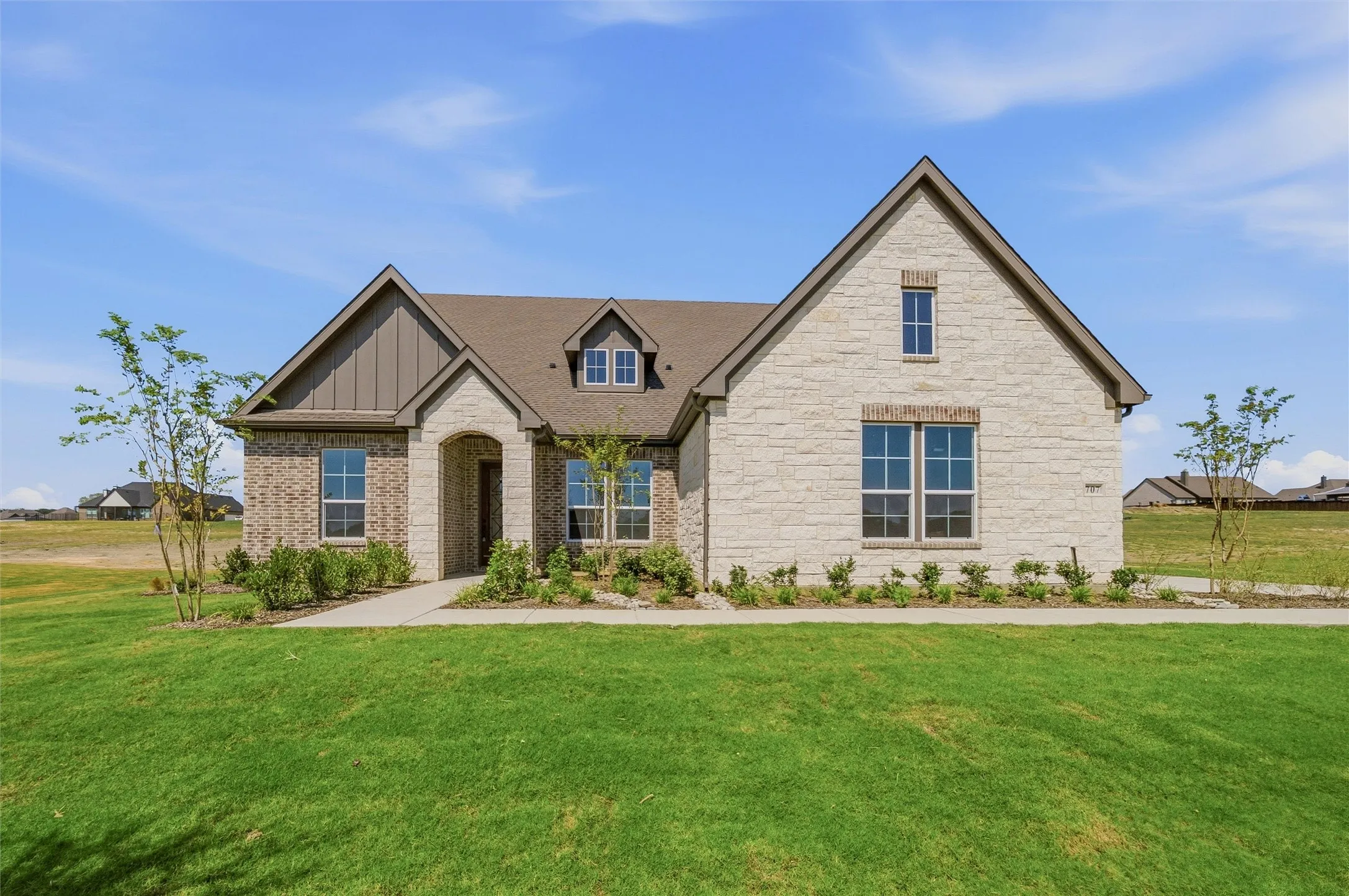 Stone and brick exterior with a gabled roofline and multiple windows