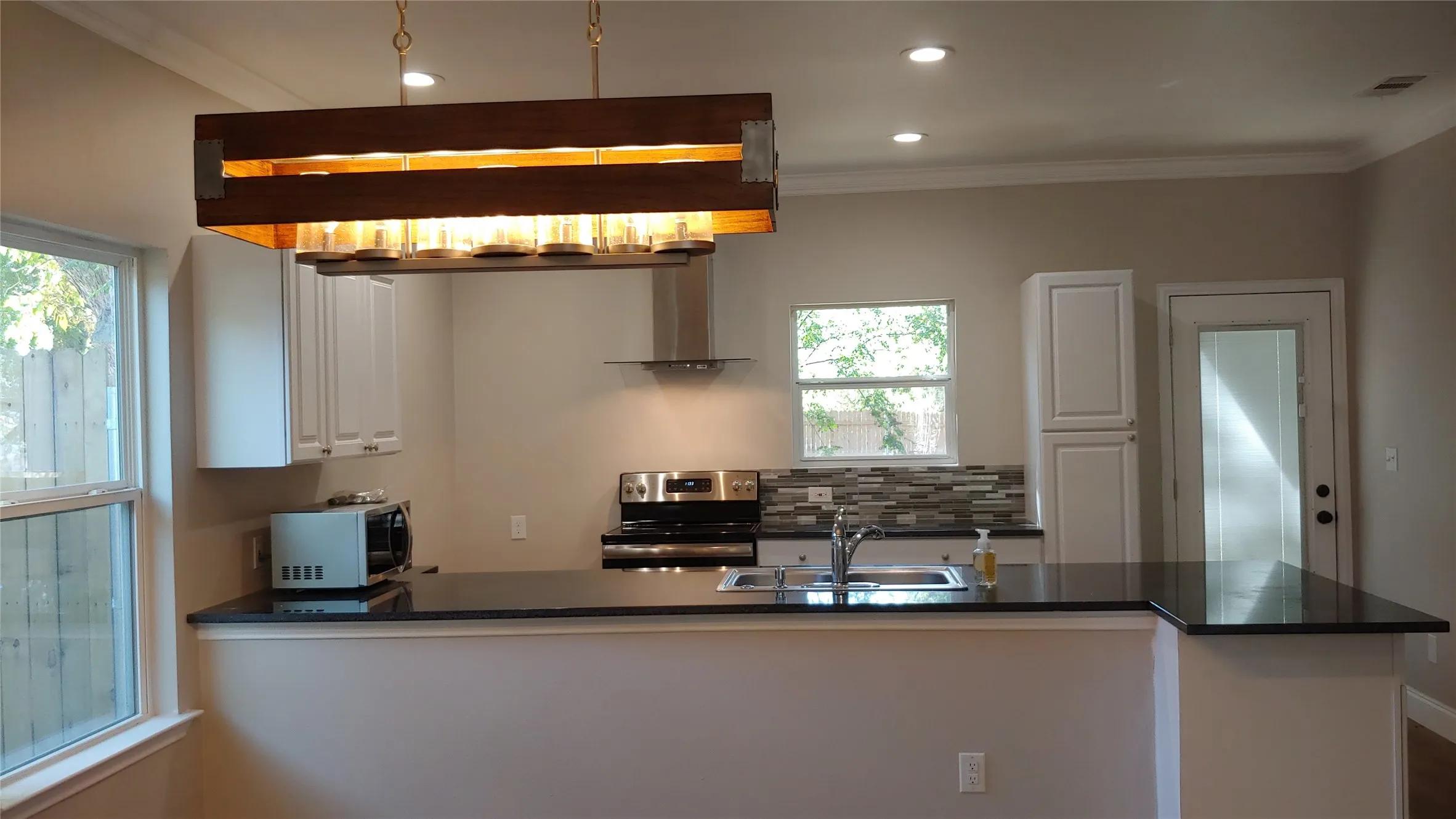Here is a view from the kitchen table looking into the kitchen. Notice the windows and door to access the back yard.
