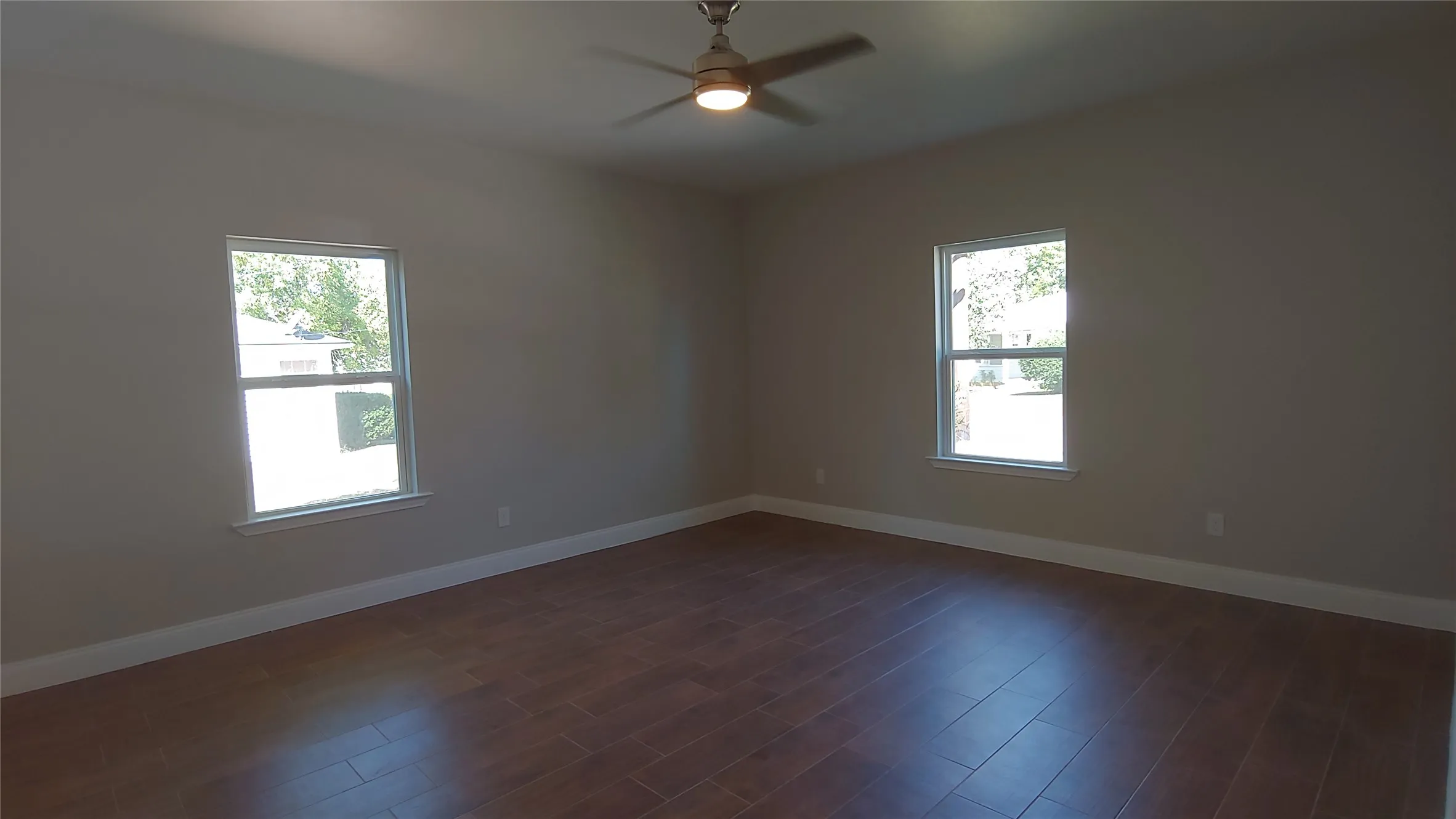 Here is a wonderful living area with lots of open space. Notice the lovely flooring and windows.