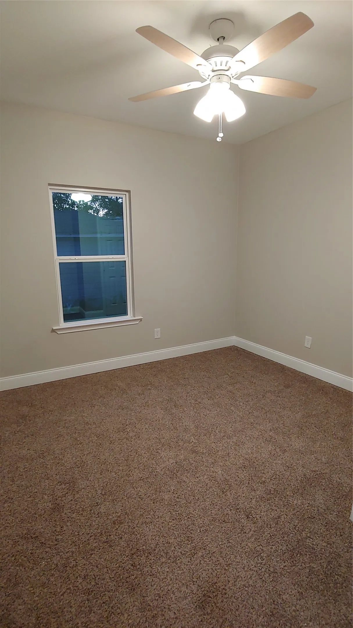 Bedroom space with nice window with a peek outside. Notice the fan to keep you cool in hot summer months.