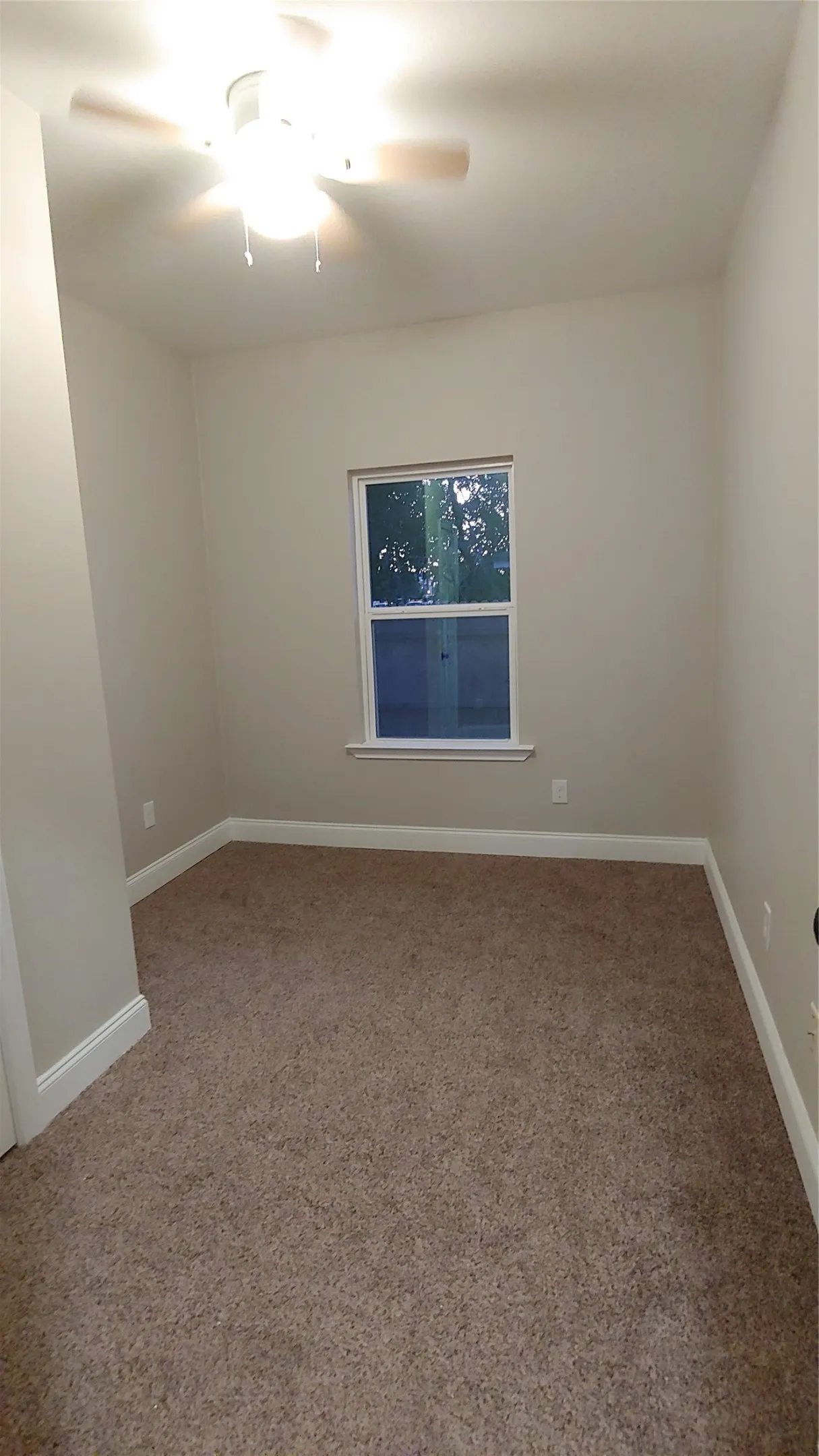 Bedroom or office space with a window to allow natural lighting in. Notice the fan to keep you cool in hot summer months.