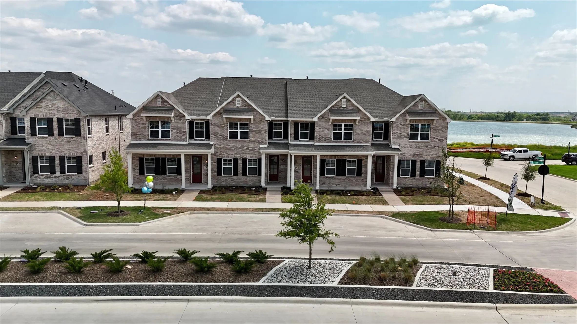 View of front of house with a porch, brick siding, and a water view