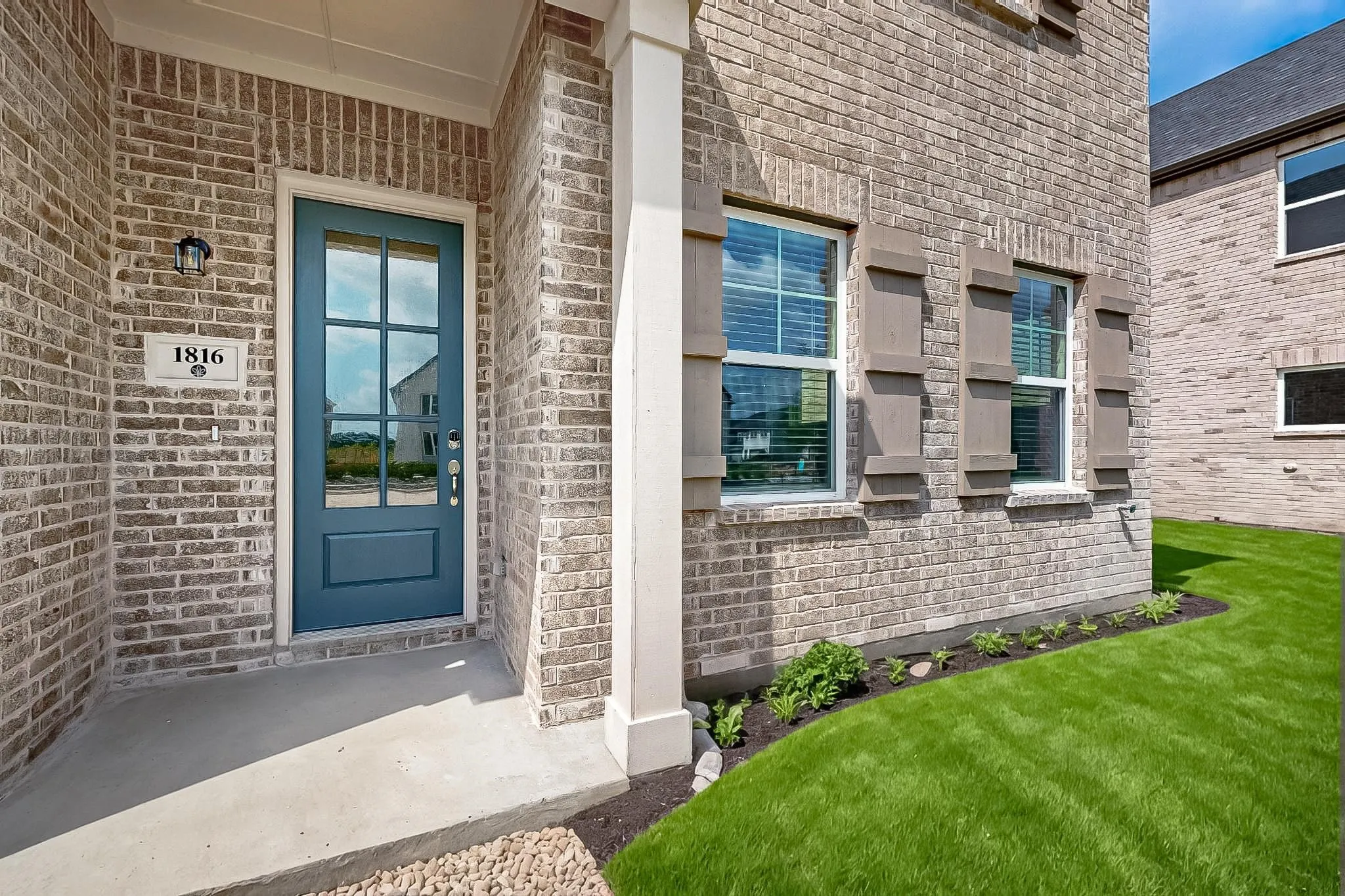 View of exterior entry with brick siding, a porch, and a​​‌​​​​‌​​‌‌​‌‌​​​‌‌​‌​‌​‌​​​‌​​ yard