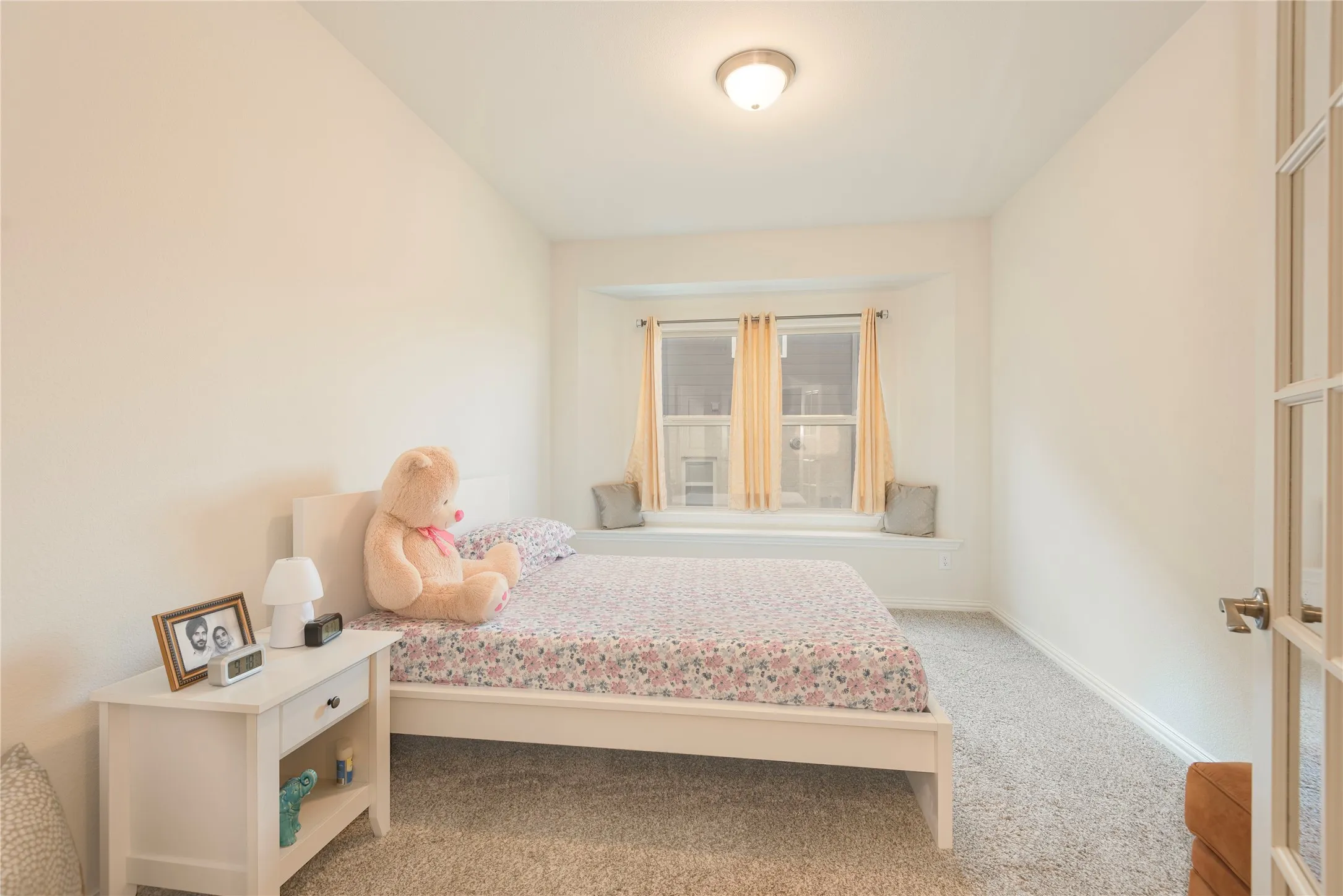 Room featuring a built-in window seat, plush carpet flooring, and a semi-flush ceiling light fixture