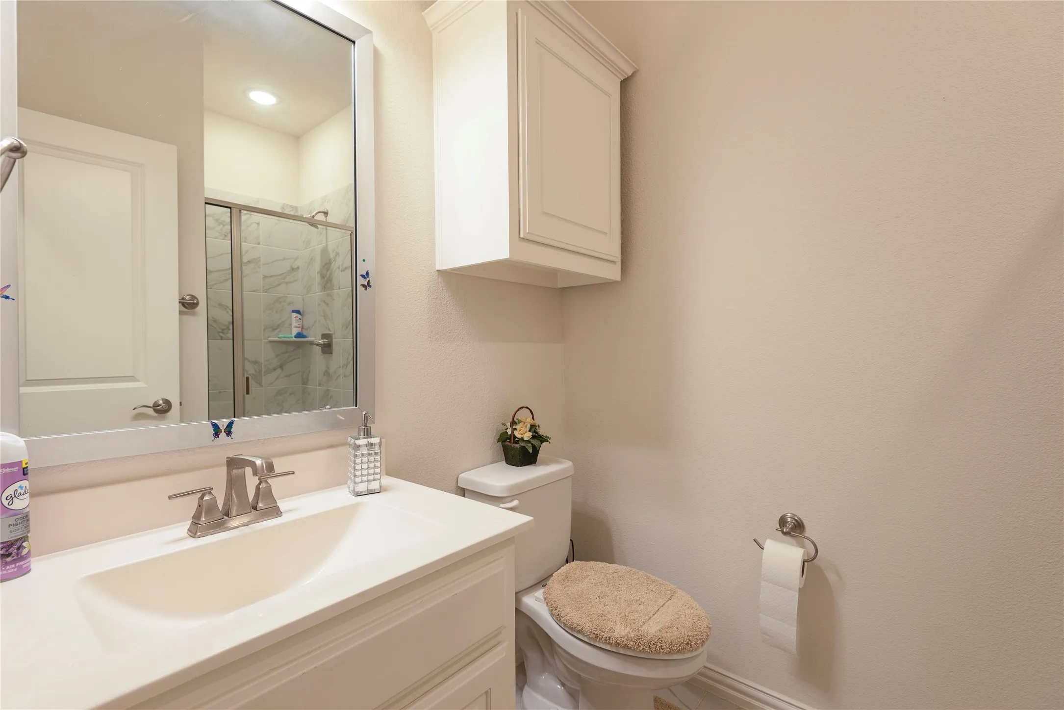 Bathroom featuring a vanity with an integrated sink, brushed nickel faucet, and a wall-mounted mirror