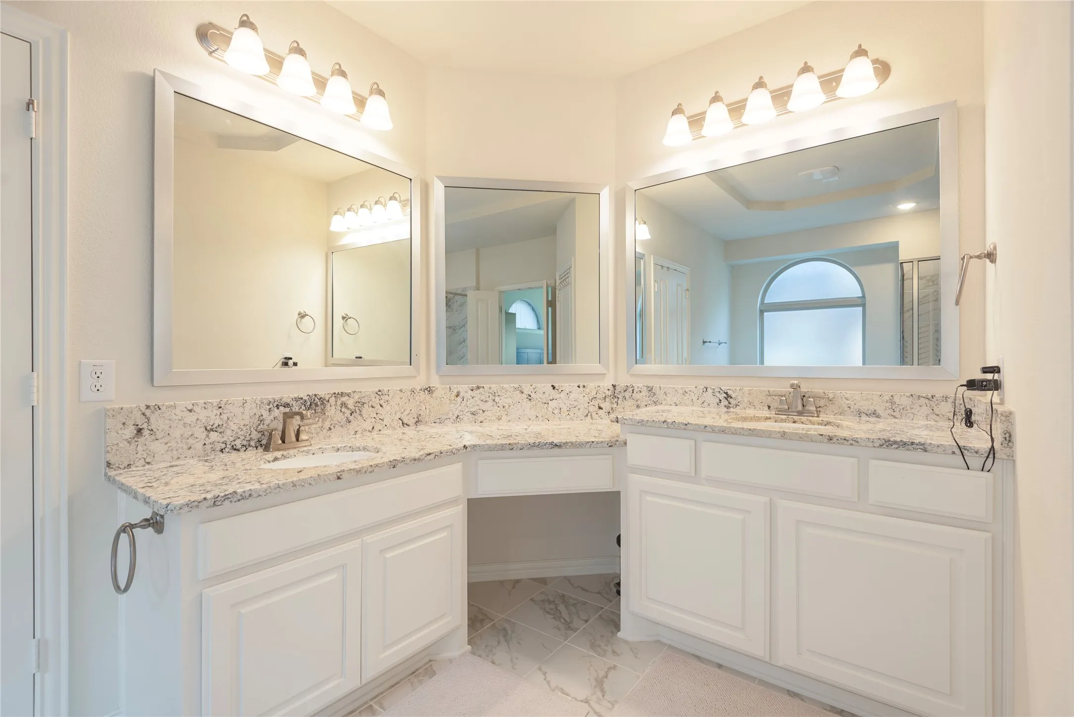 Expansive vanity area featuring dual integrated sinks, white cabinetry, and granite countertops