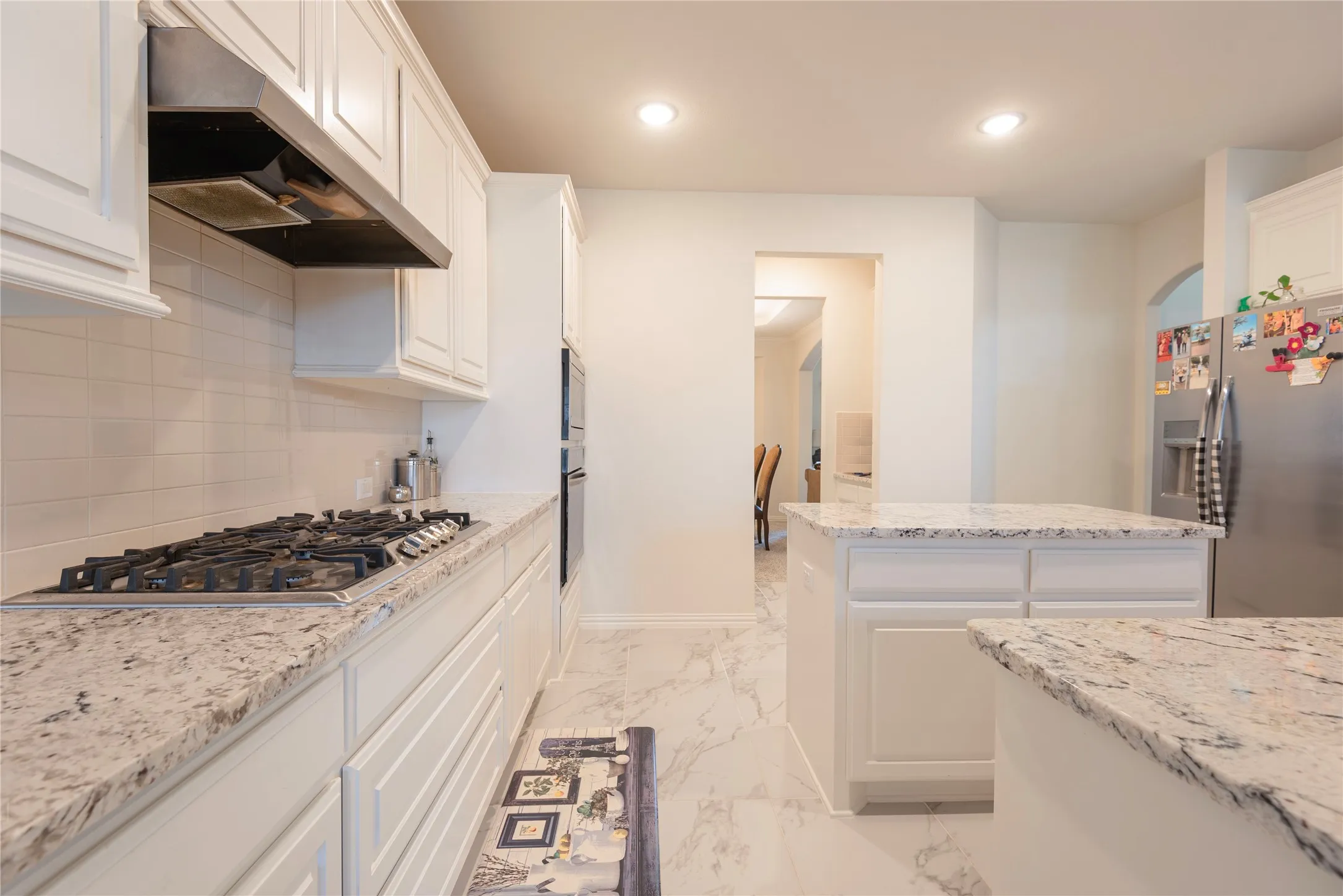 Kitchen featuring white cabinetry and light-toned countertops