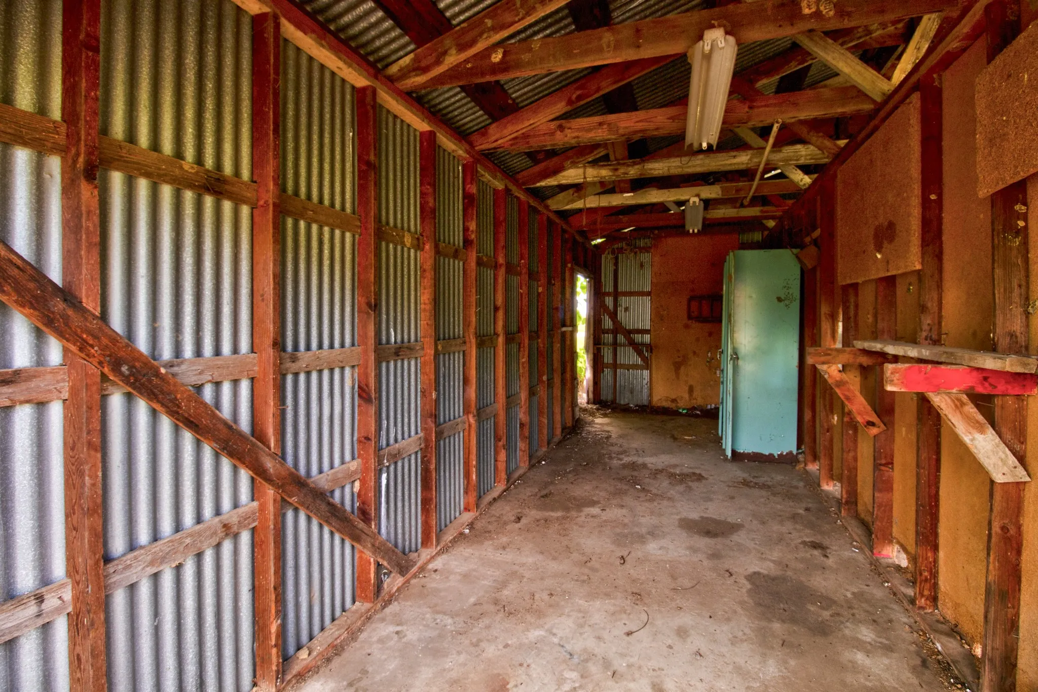 Open-air structure featuring exposed wood framing and corrugated metal paneling