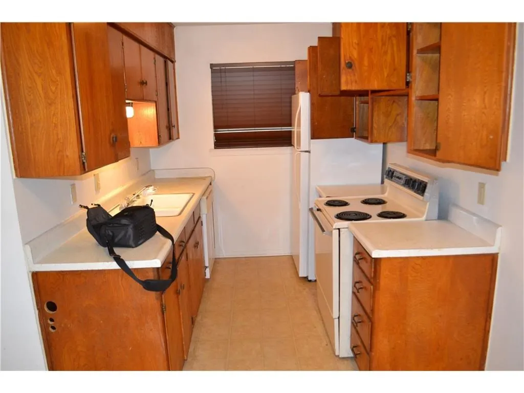 Charming kitchen featuring classic wood cabinetry and a bright, functional workspace.
