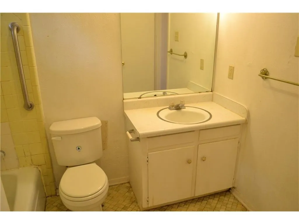 Clean and polished bathroom equipped with a spacious vanity and ample lighting.