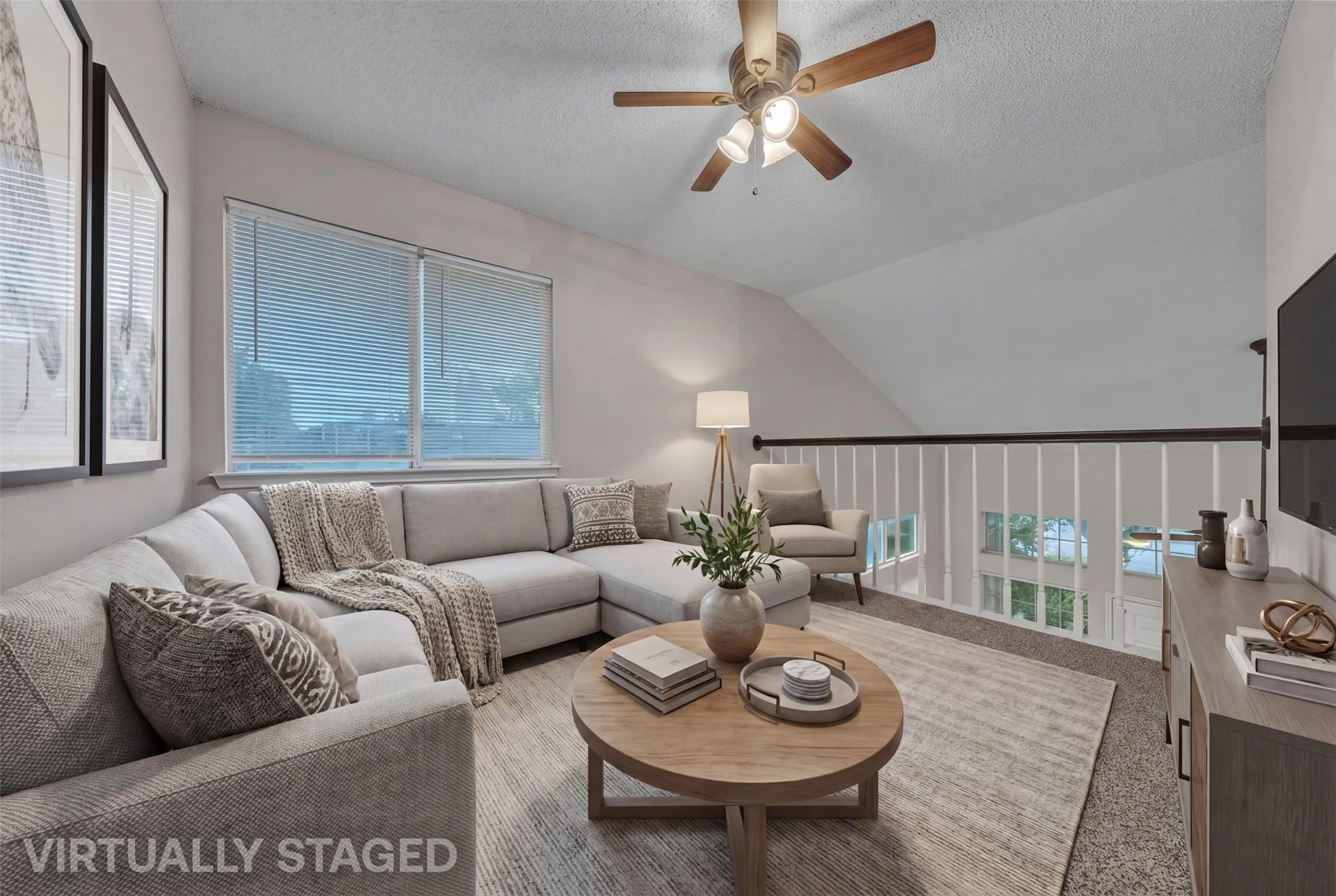 Vaulted ceilings enhance this living area with a ceiling fan, window blinds, and a durable carpeted floor