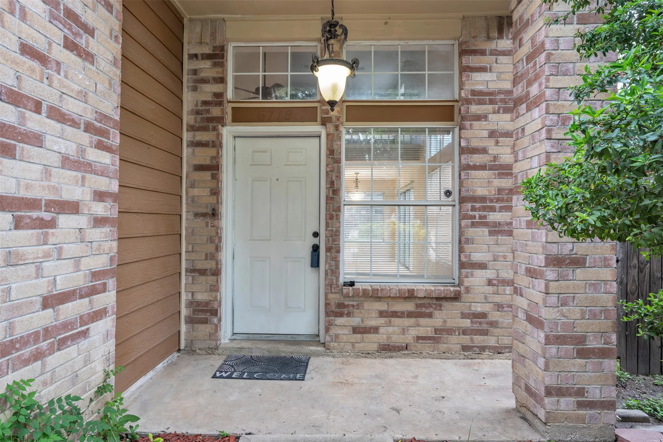 Entryway featuring a white paneled door, decorative hanging light fixture, and an adjacent window with grid panes