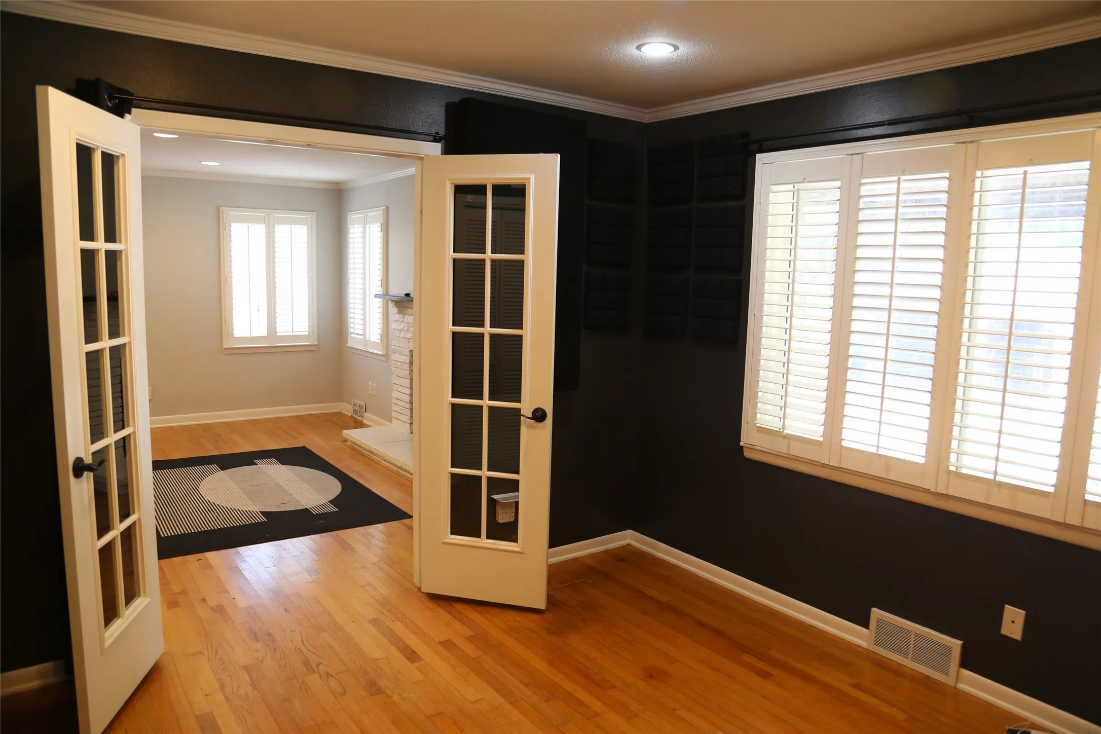 Interior room with wood-finish flooring and crown molding