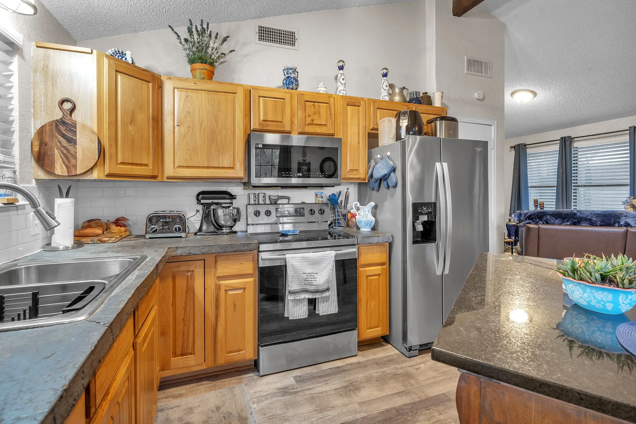 Kitchen view highlighting appliances and workspace with an open feel to the living area.
