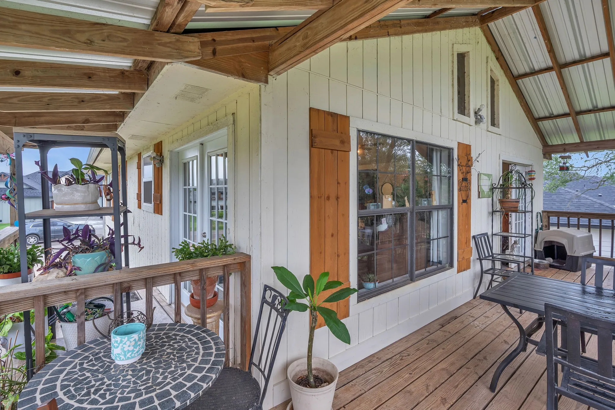 Covered front deck with seating space and peaceful views. A welcoming spot to relax and enjoy the outdoors.