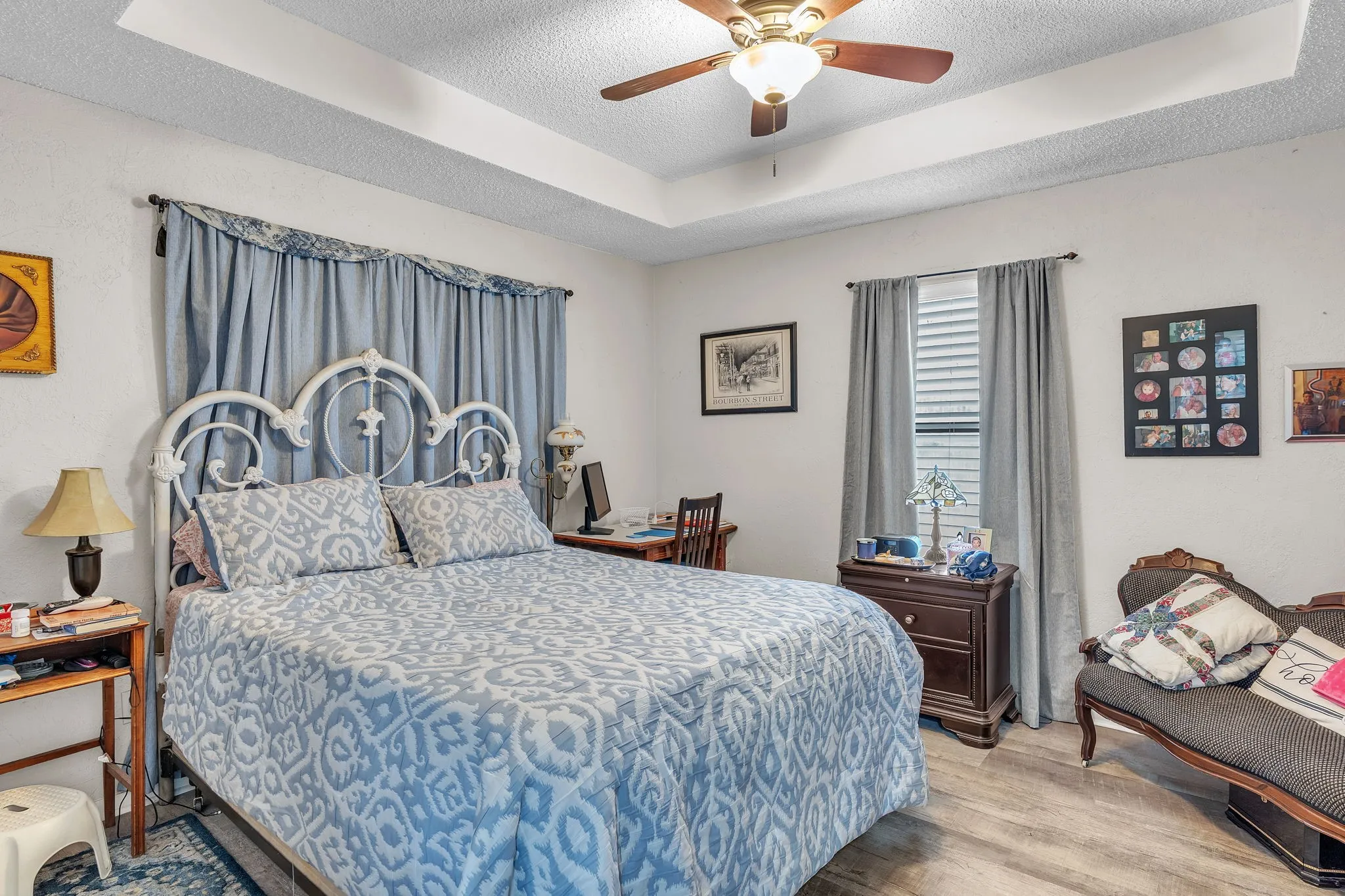 Primary bedroom featuring a tray ceiling and soft natural light. A relaxing and spacious retreat.
