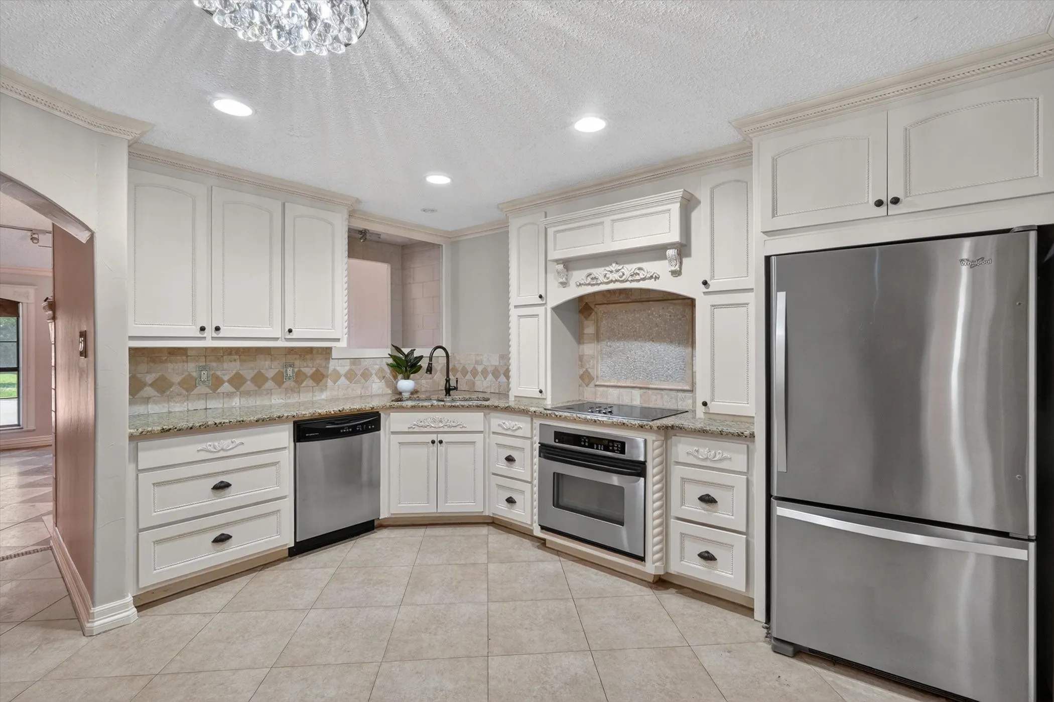 Kitchen featuring white cabinetry, stainless steel appliances, granite countertops, a tiled backsplash, and recessed lighting