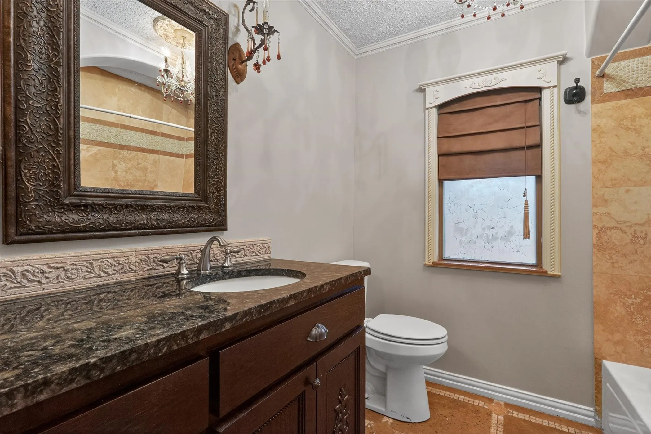 Bathroom vanity featuring a dark stone countertop, undermount sink, and brushed nickel faucet
