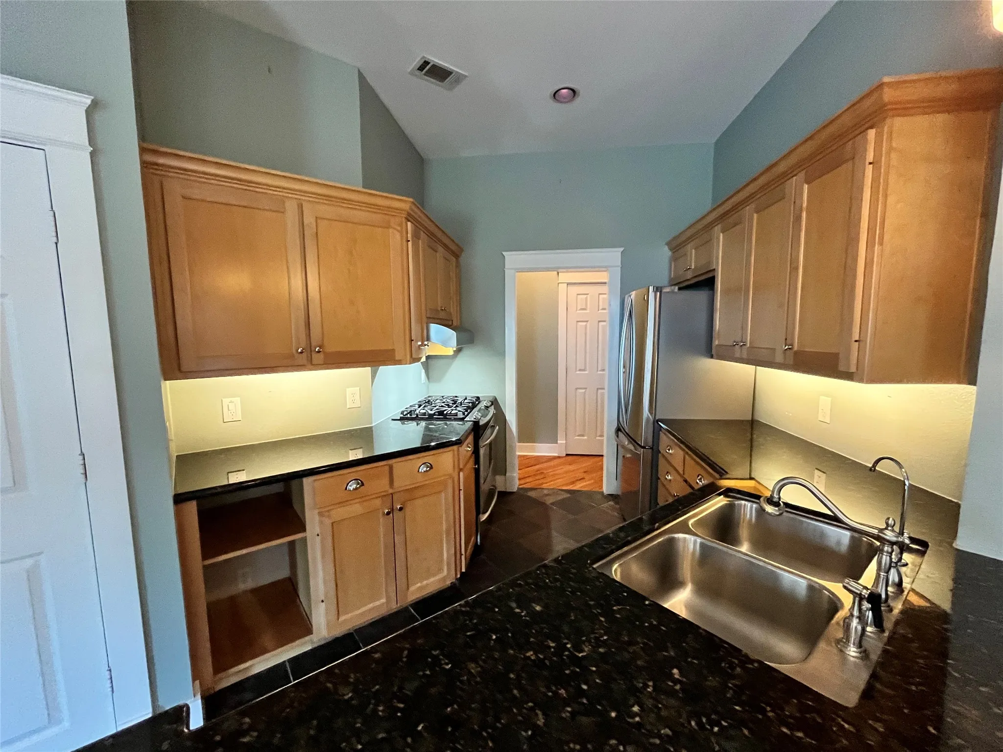 Updated kitchen with plenty of cabinet space and dark countertops.
