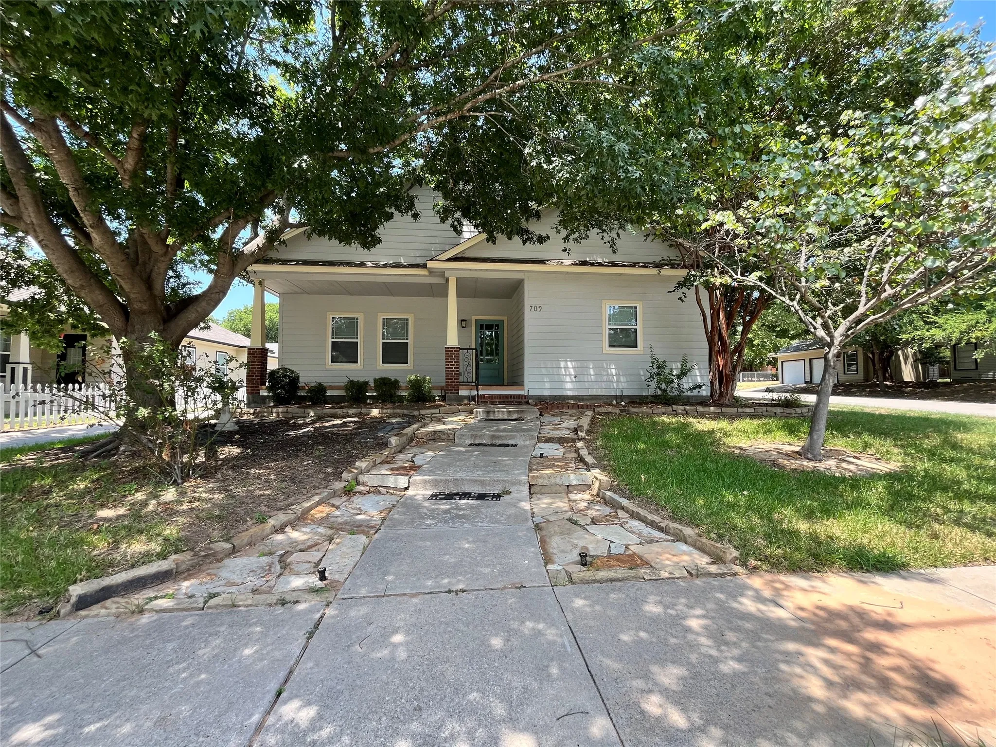 Wide shot of the front yard and paved walkway.