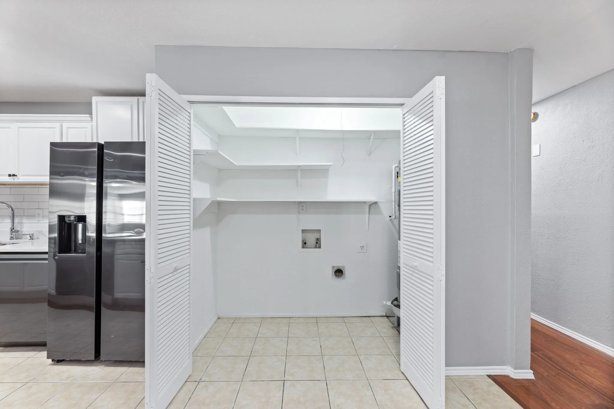 Laundry room with light tile patterned floors and hookup for a washing machine