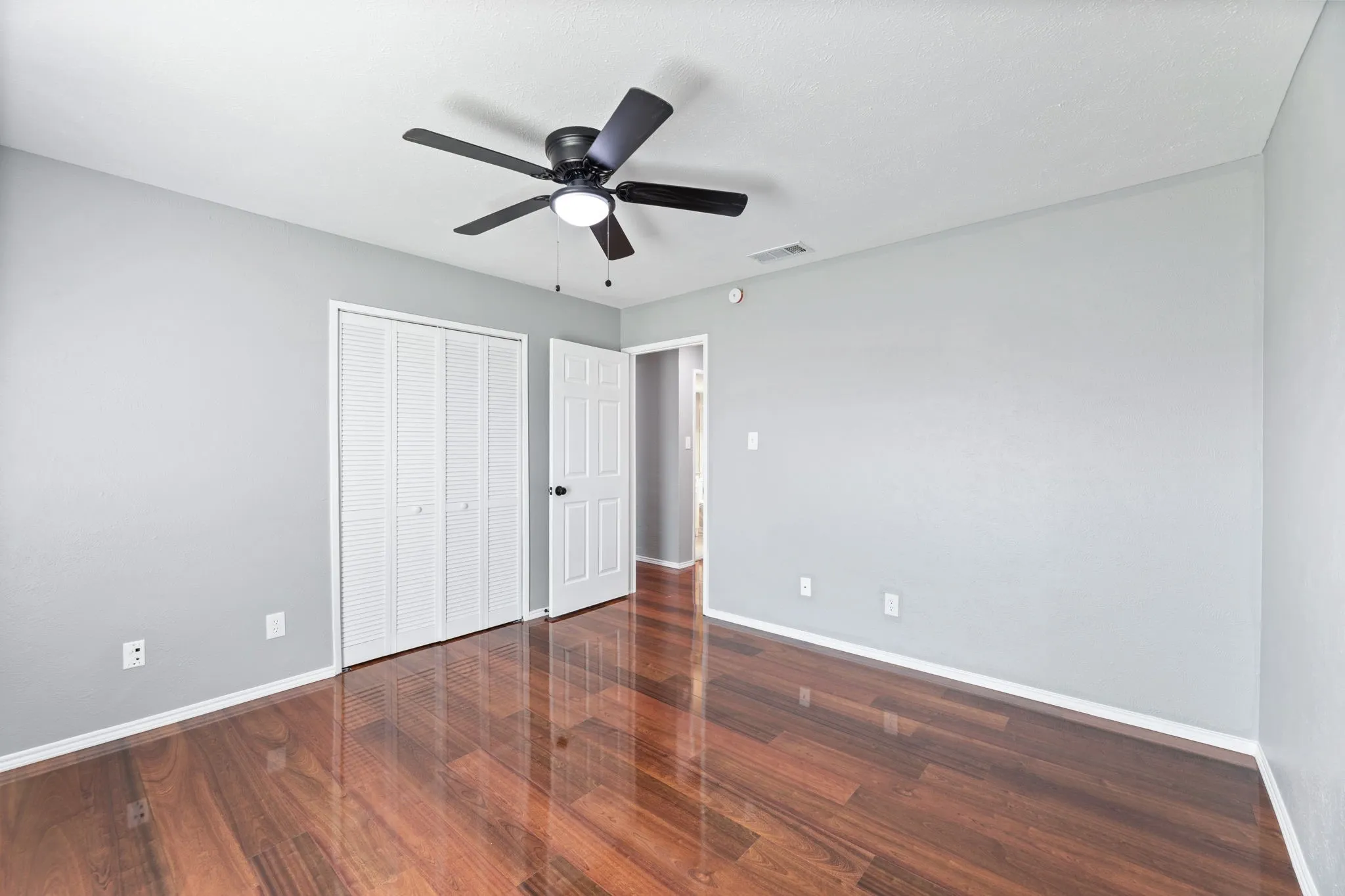 2nd bedroom featuring dark wood-type flooring, a ceiling fan, and a closet