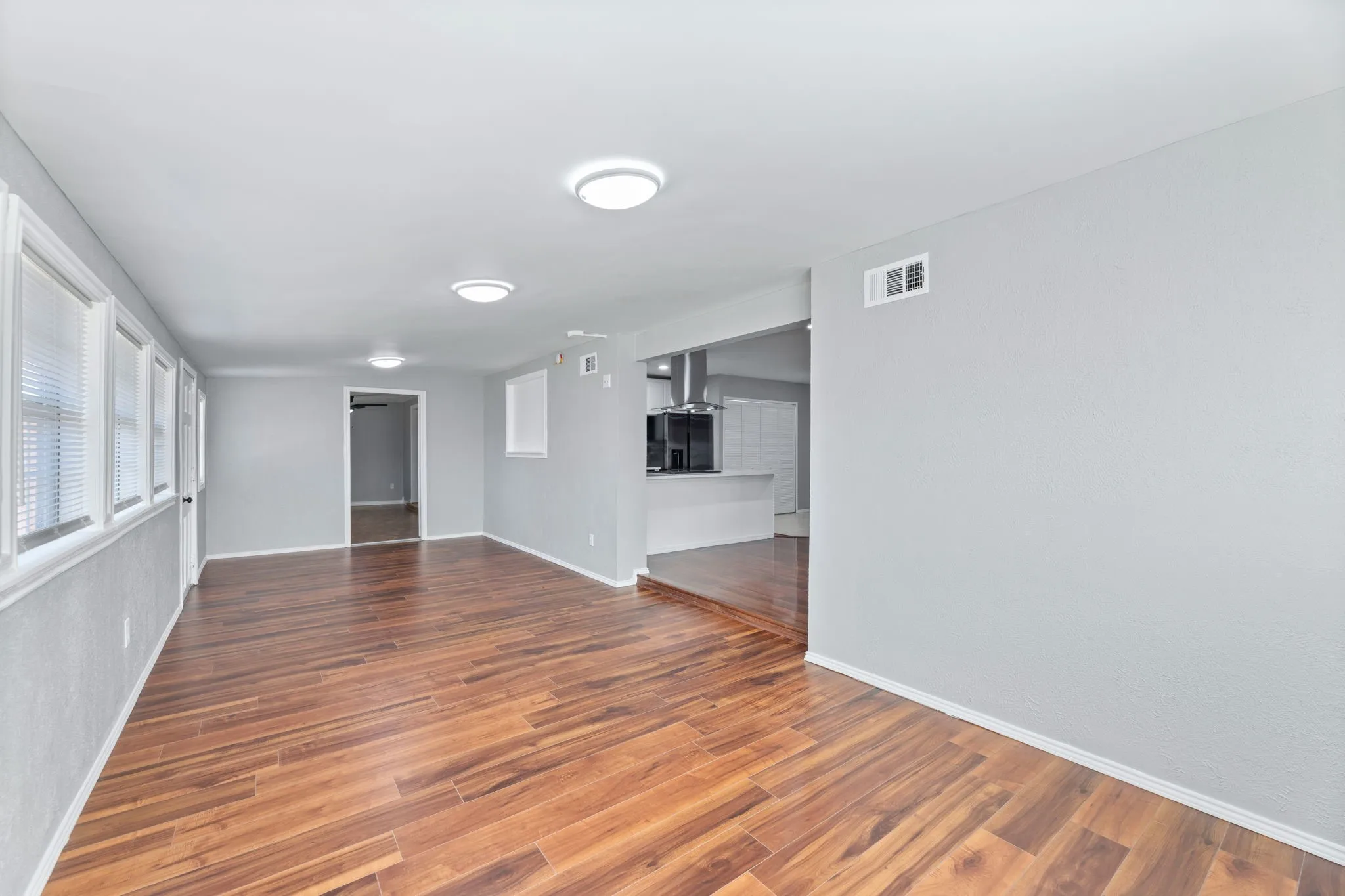 Bonus room featuring dark wood-type flooring & baseboards. Playroom, sitting area, study, a great addition to the home! Just off family room and kitchen. Door leads to back yard.