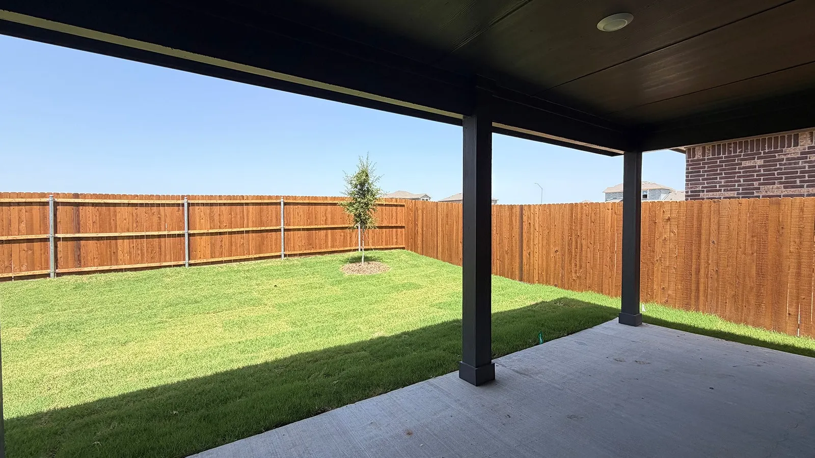 Covered patio with recessed lighting, concrete flooring, and dark-stained structural posts