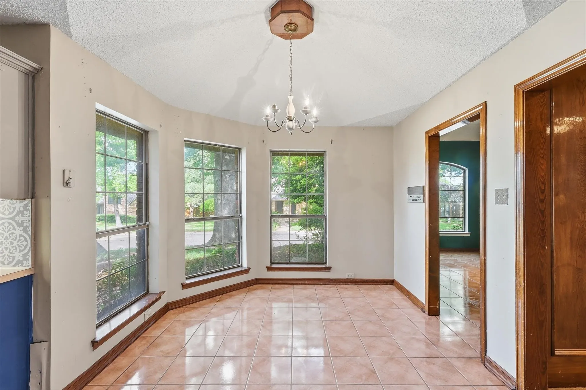 Dining space featuring terra cotta tile flooring and a multi-window bay