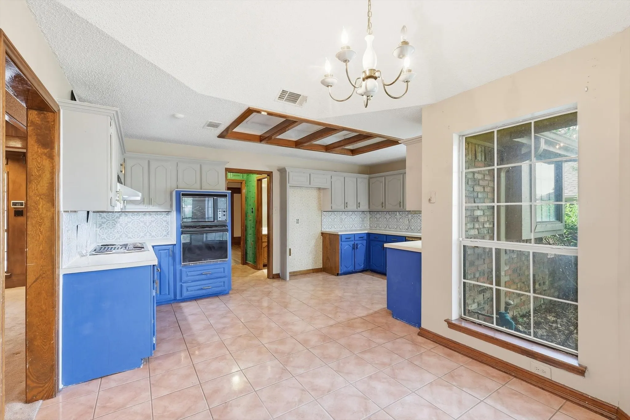 Spacious kitchen featuring tile flooring, a built-in double oven, and a large window