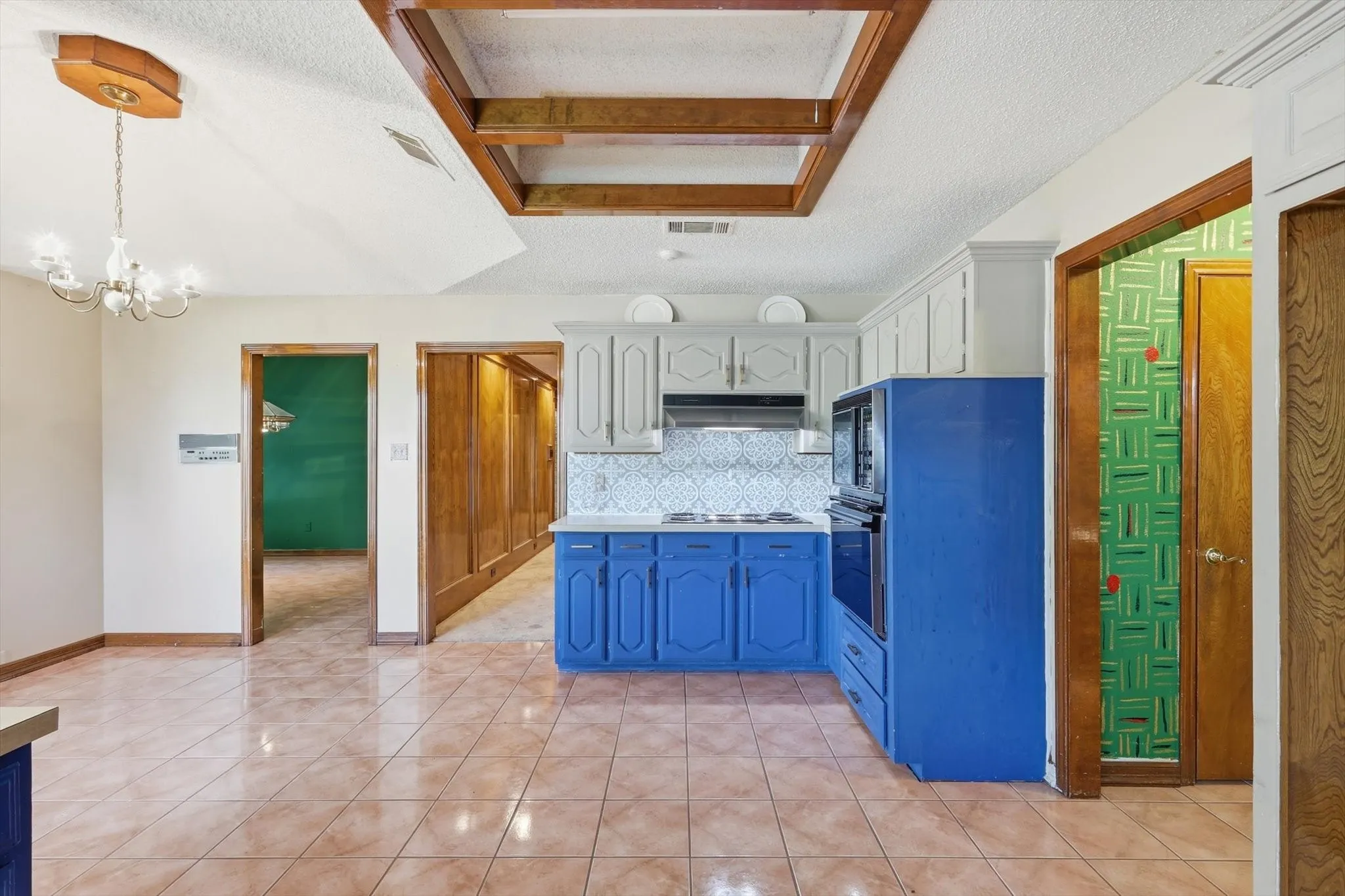 Kitchen featuring blue base cabinetry, light gray upper cabinetry, an integrated wall oven, and a built-in microwave