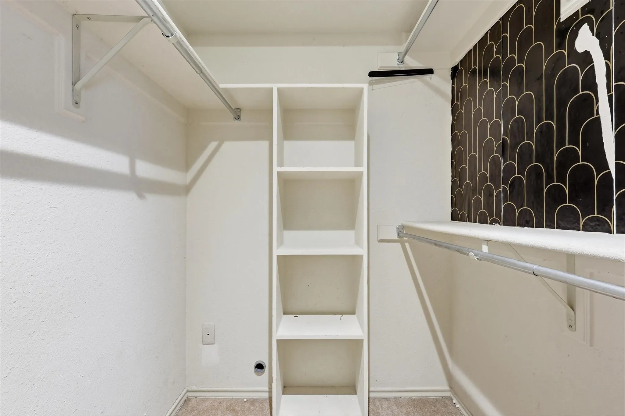 Custom closet system featuring built-in shelving, dual hanging rods, and a decorative tiled accent wall