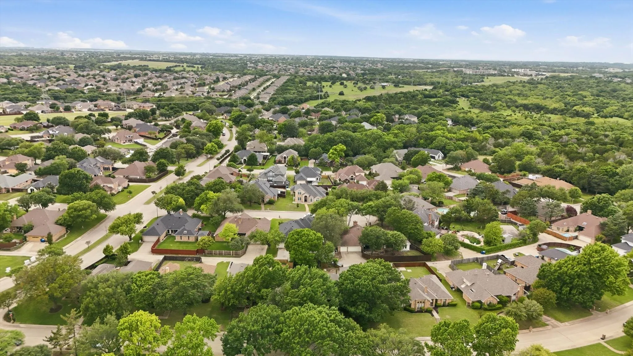 Expansive neighborhood featuring numerous residential properties with mature trees and paved streets