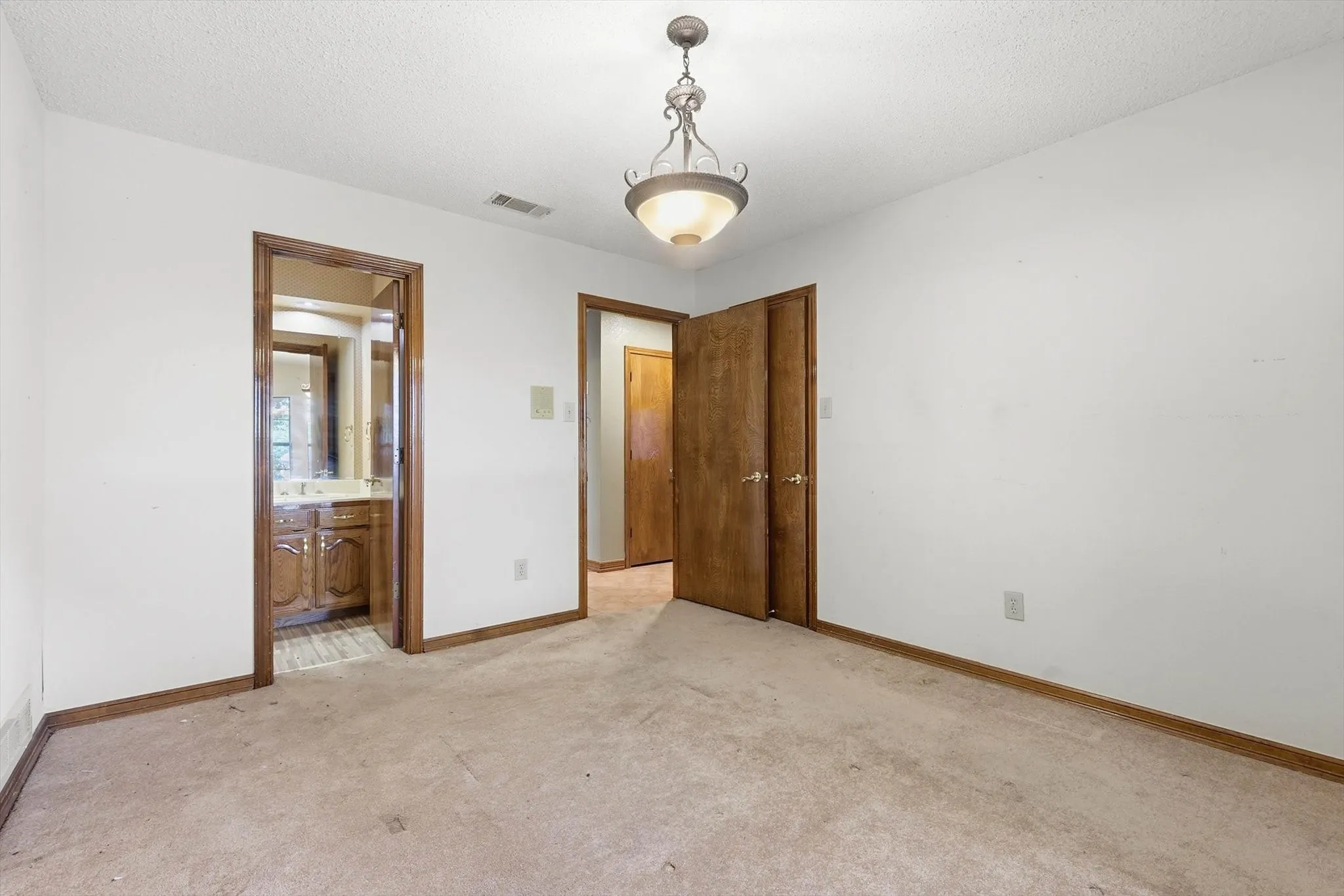 Carpeted interior space featuring white walls and wood-finish trim